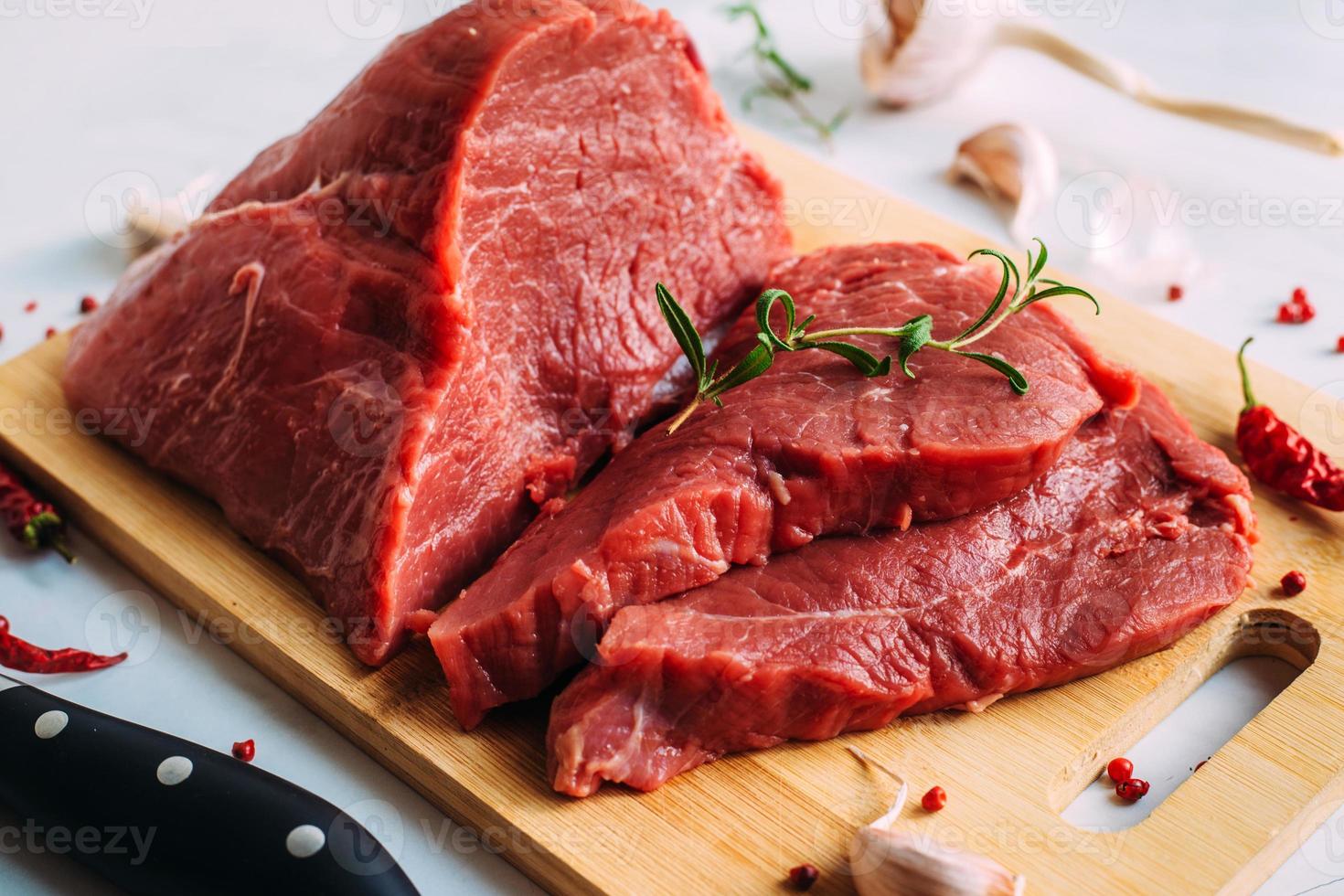 Fresh pork raw fillet on wooden board. Red beef meat on a cutting board. photo