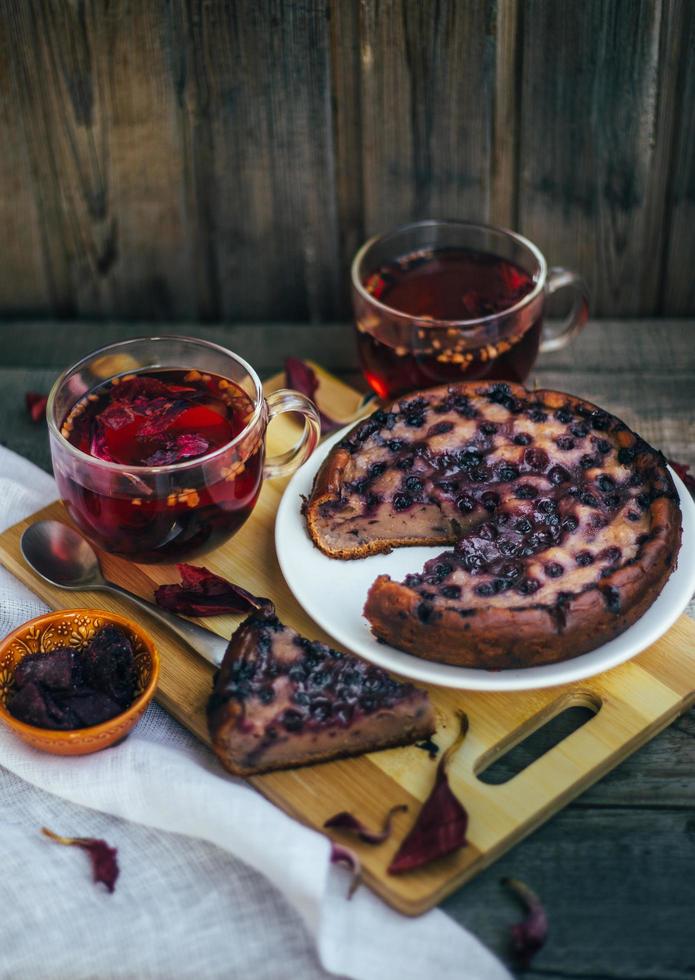 Imperfect blueberry pie. A cozy home-made tea party. Wooden background and white linen. photo