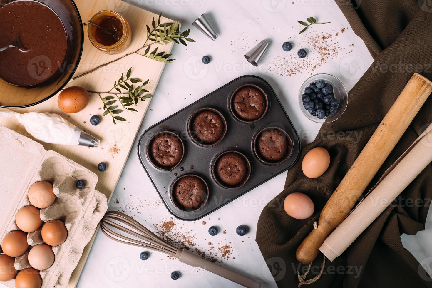 cupcakes with cream and blueberries on kitchen table photo