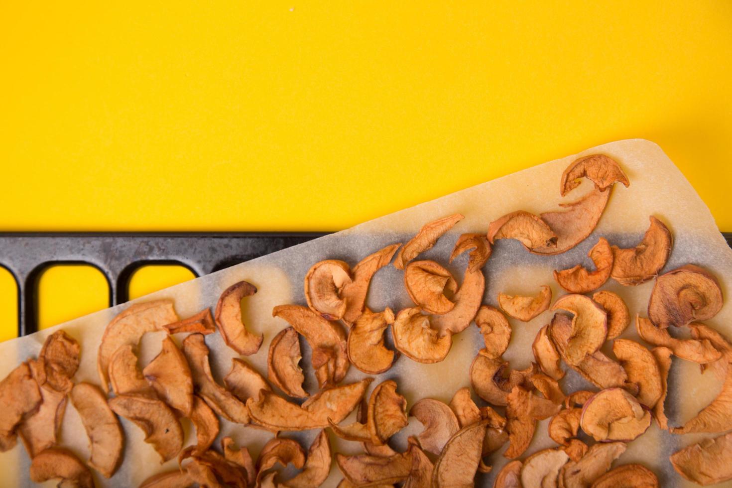 Homemade dried organic apple sliced on yellow background. photo