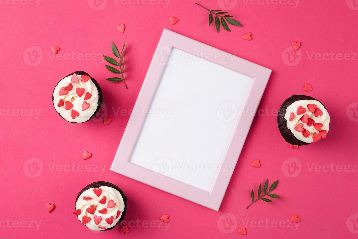 Red velvet cupcakes for Valentines Day in bright pink setting photo