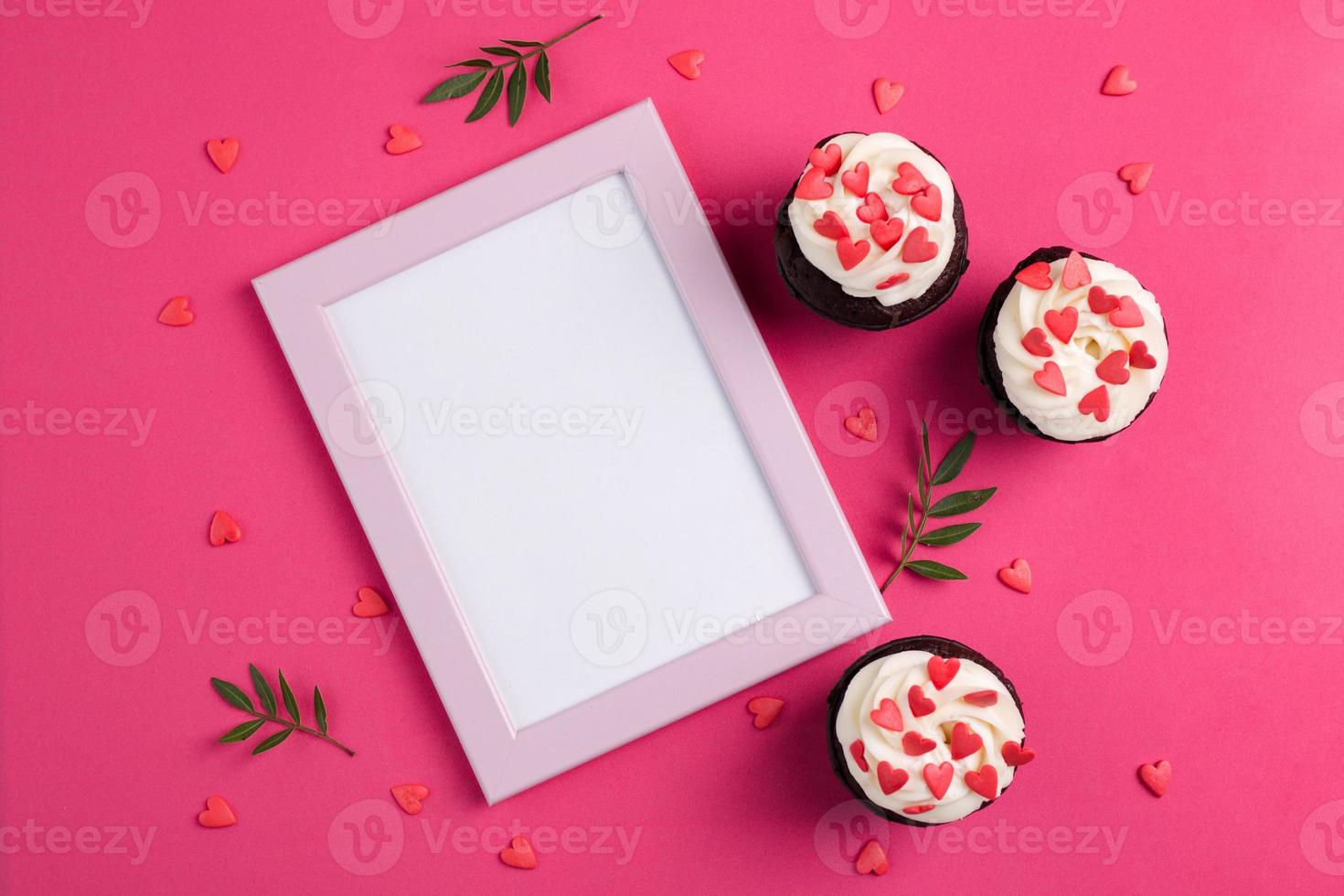 Red velvet cupcakes for Valentines Day in bright pink setting photo