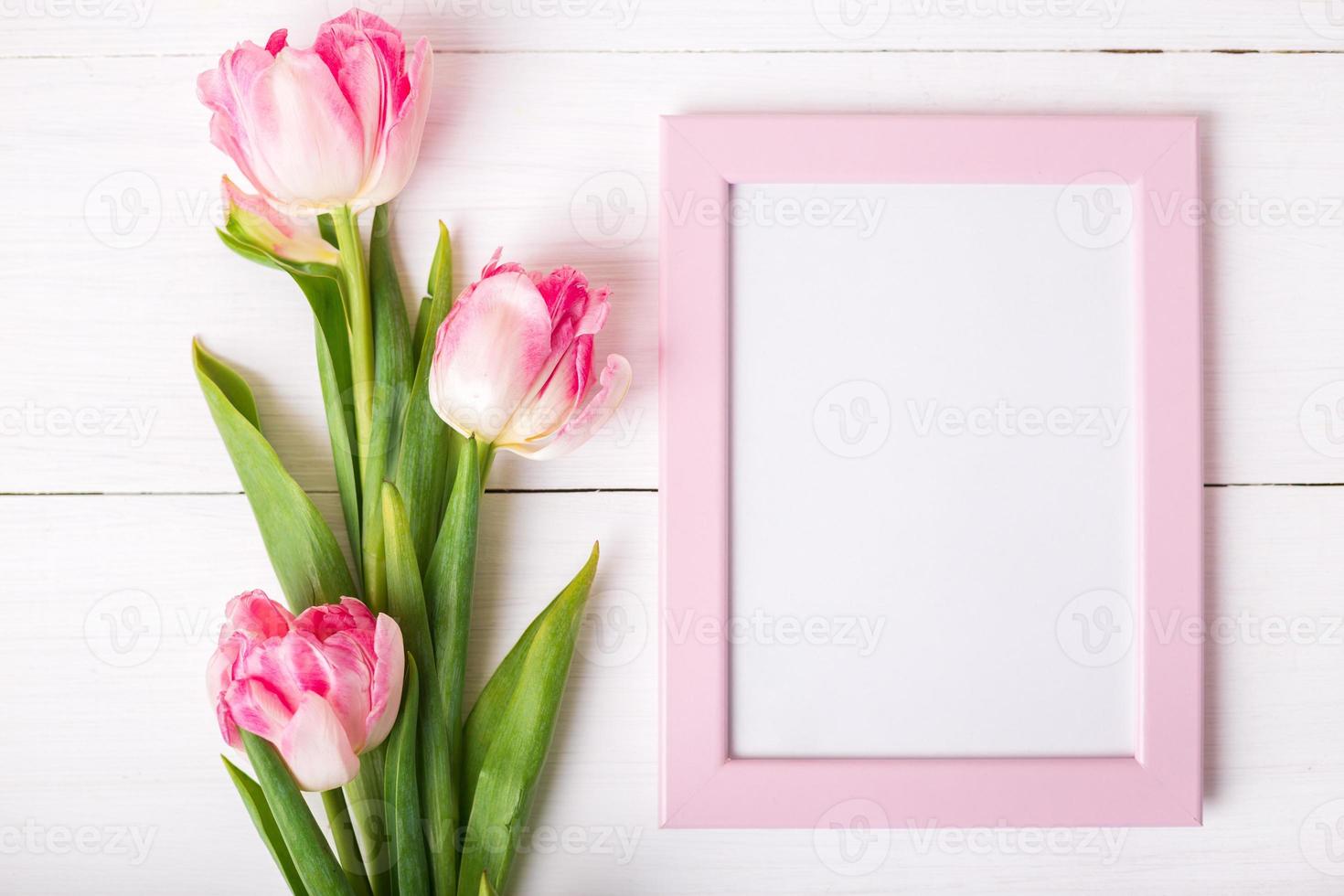 Beautiful white and pink tulips, photo frame for text on white wooden background.