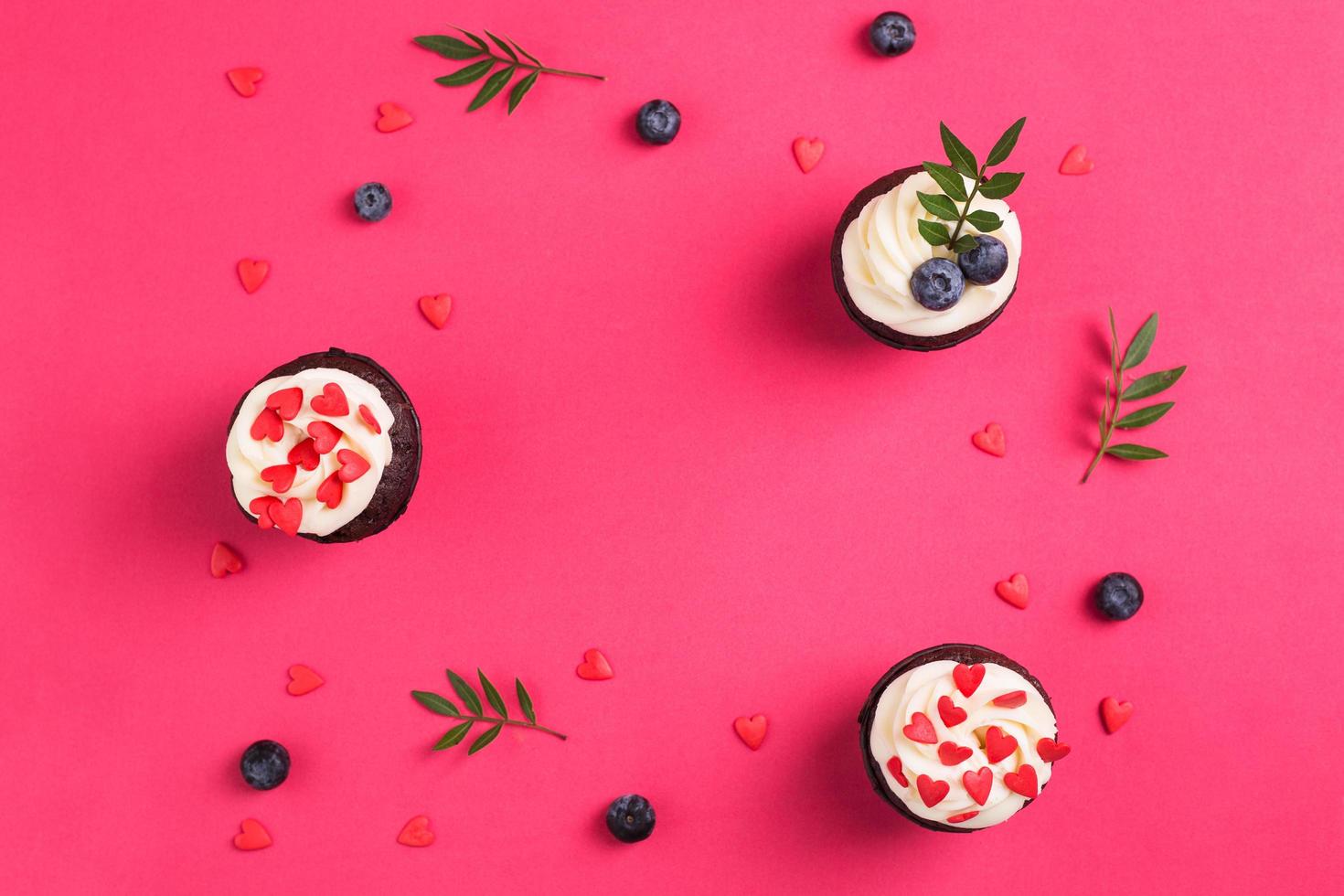 Red velvet cupcakes for Valentines Day in bright pink setting photo