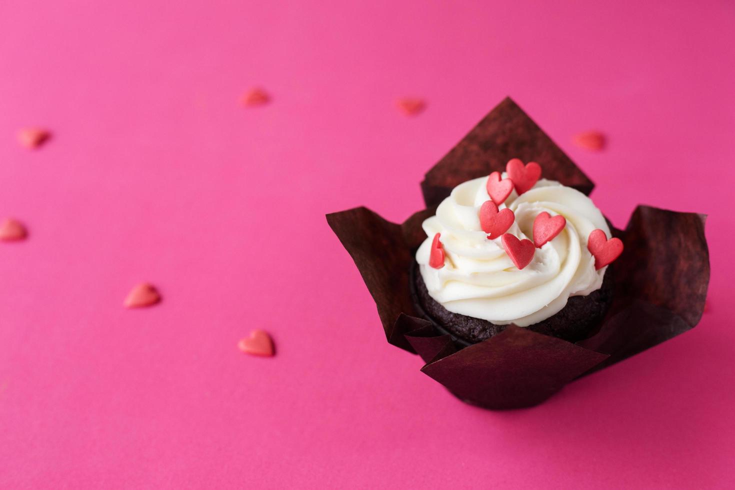 Red velvet cupcakes for Valentines Day in bright pink setting photo