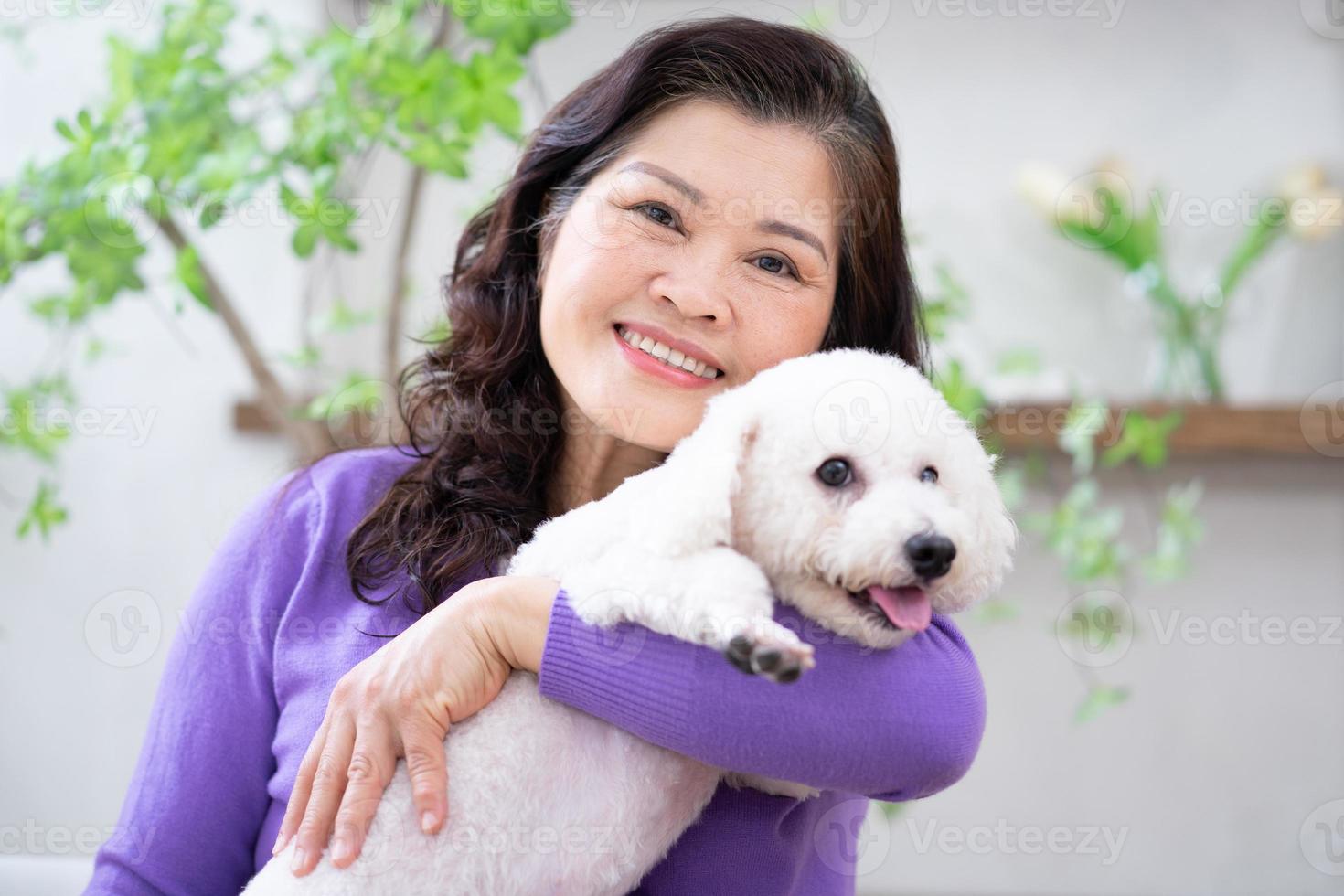 Portrait of senior woman hugging her dog photo