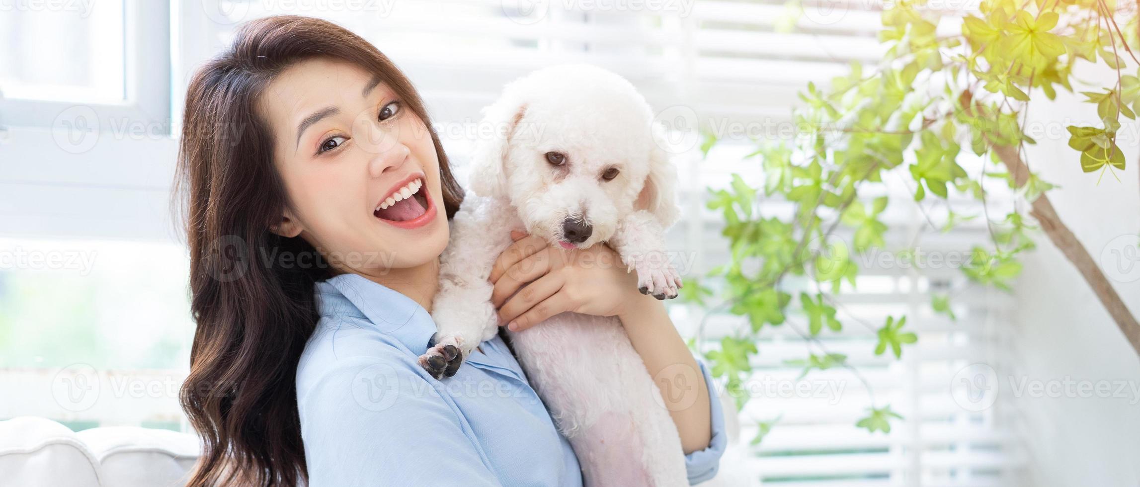 Young Asian woman playing with dog at home photo