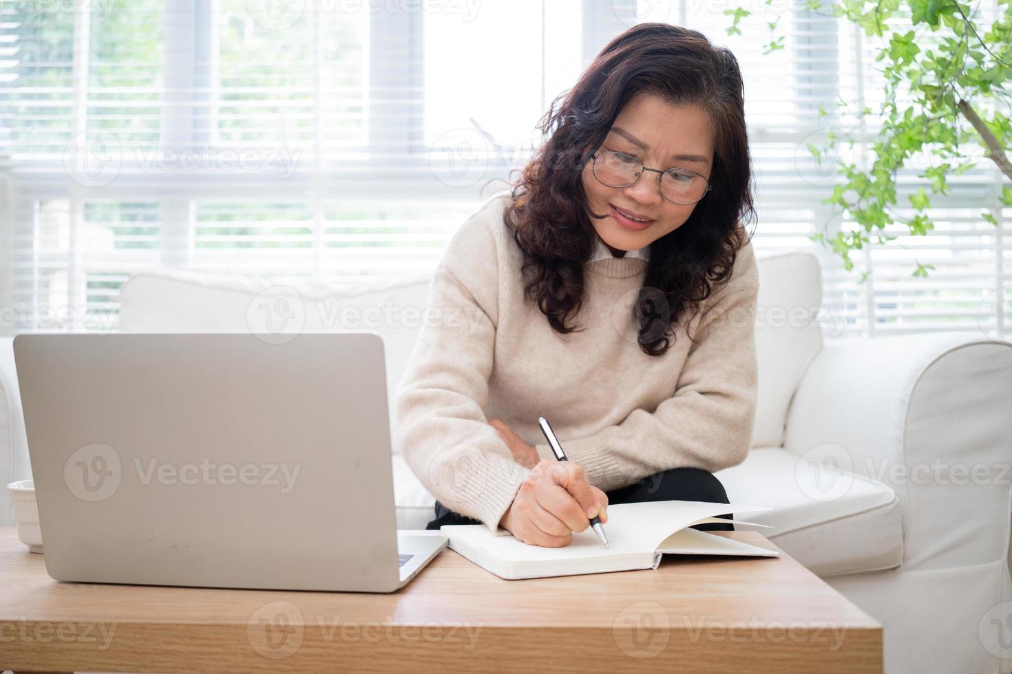 imagen de una mujer de negocios asiática mayor trabajando en casa foto