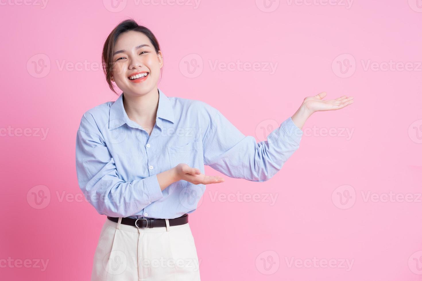 imagen de una joven y hermosa chica asiática posando sobre fondo rosa foto