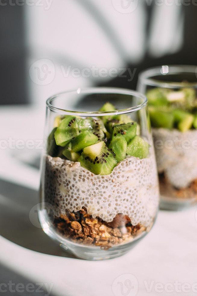 desayuno saludable. budín de chía con kiwi y granola en vaso foto