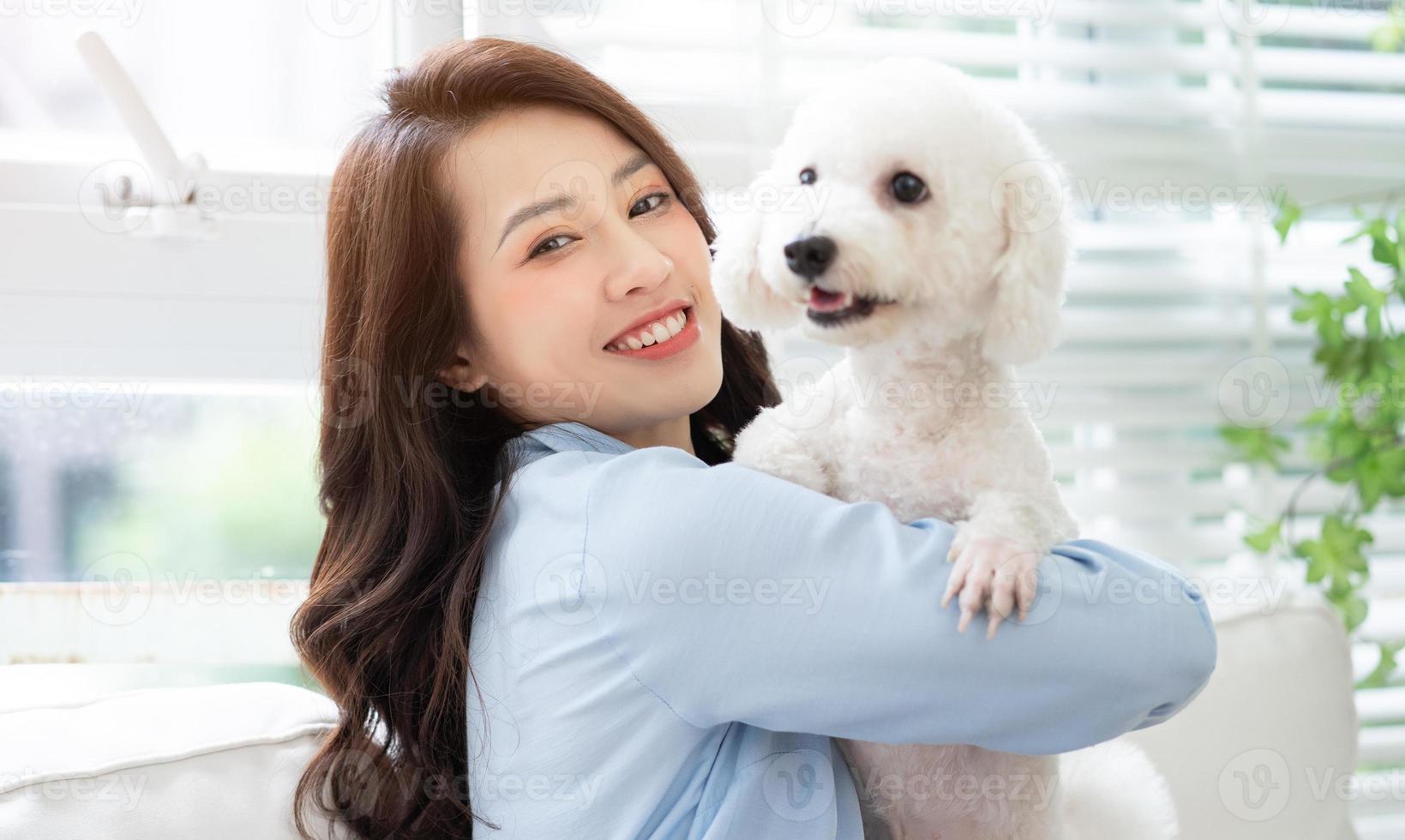 Young Asian woman playing with dog at home photo