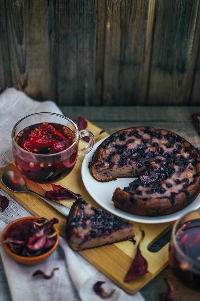 Imperfect blueberry pie. A cozy home-made tea party. Wooden background and white linen. photo