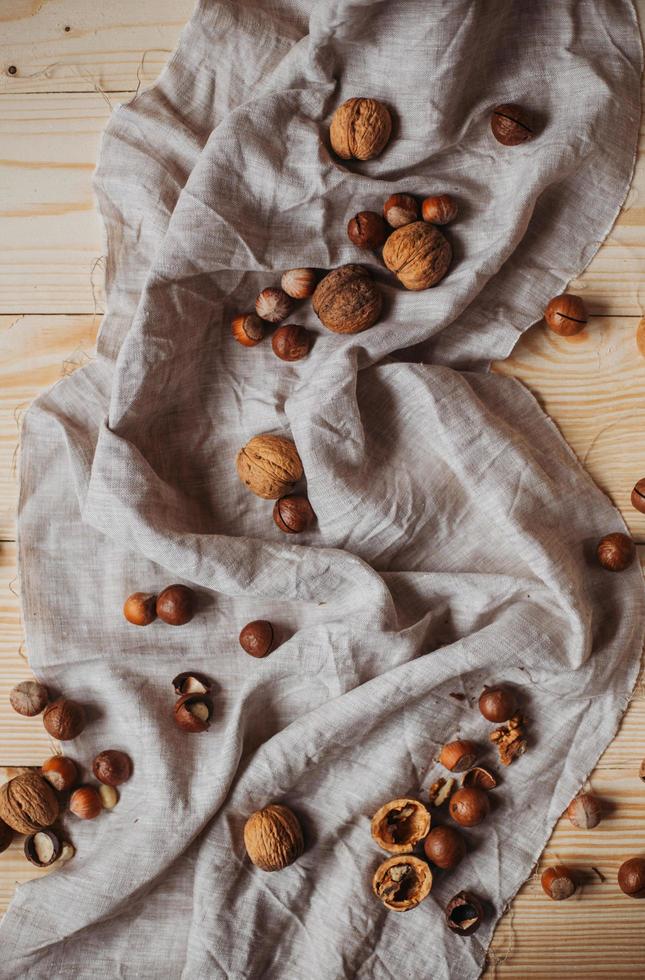 Hot cocoa with cookies, cinnamon sticks, anise, nuts on wooden background. Front view, copy space. photo