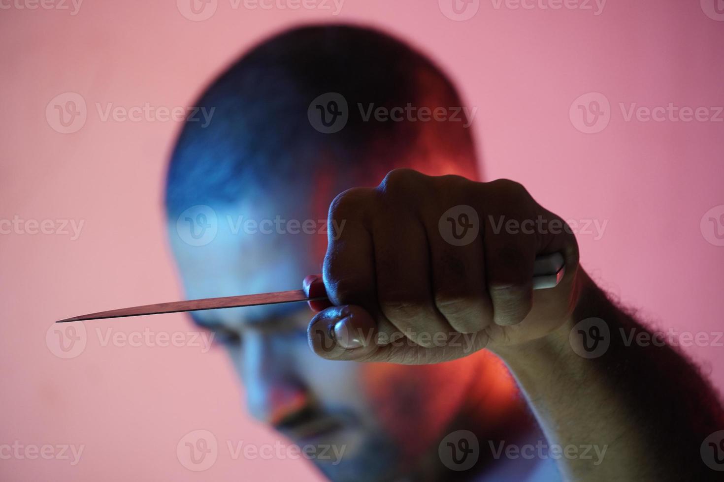 hombre enojado que tiene un cuchillo que va a matar foto