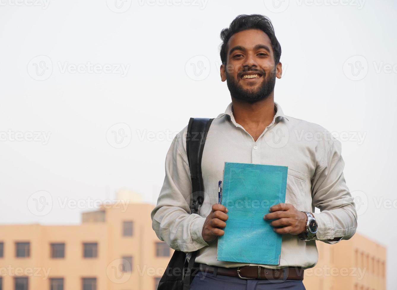 estudiante indio con libros en el campus de collage foto