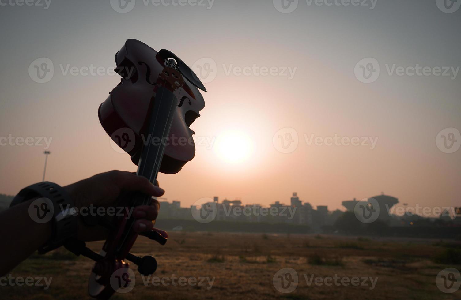 closeup of violin in hand with sun light effect photo