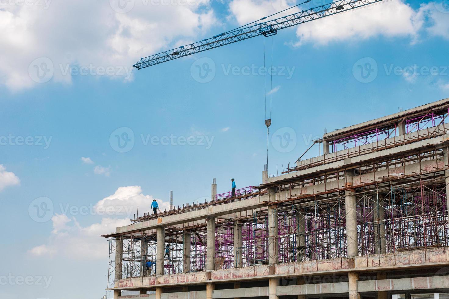 estructura de un gran edificio con trabajadores trabajando, grúas y andamios en obras de construcción foto