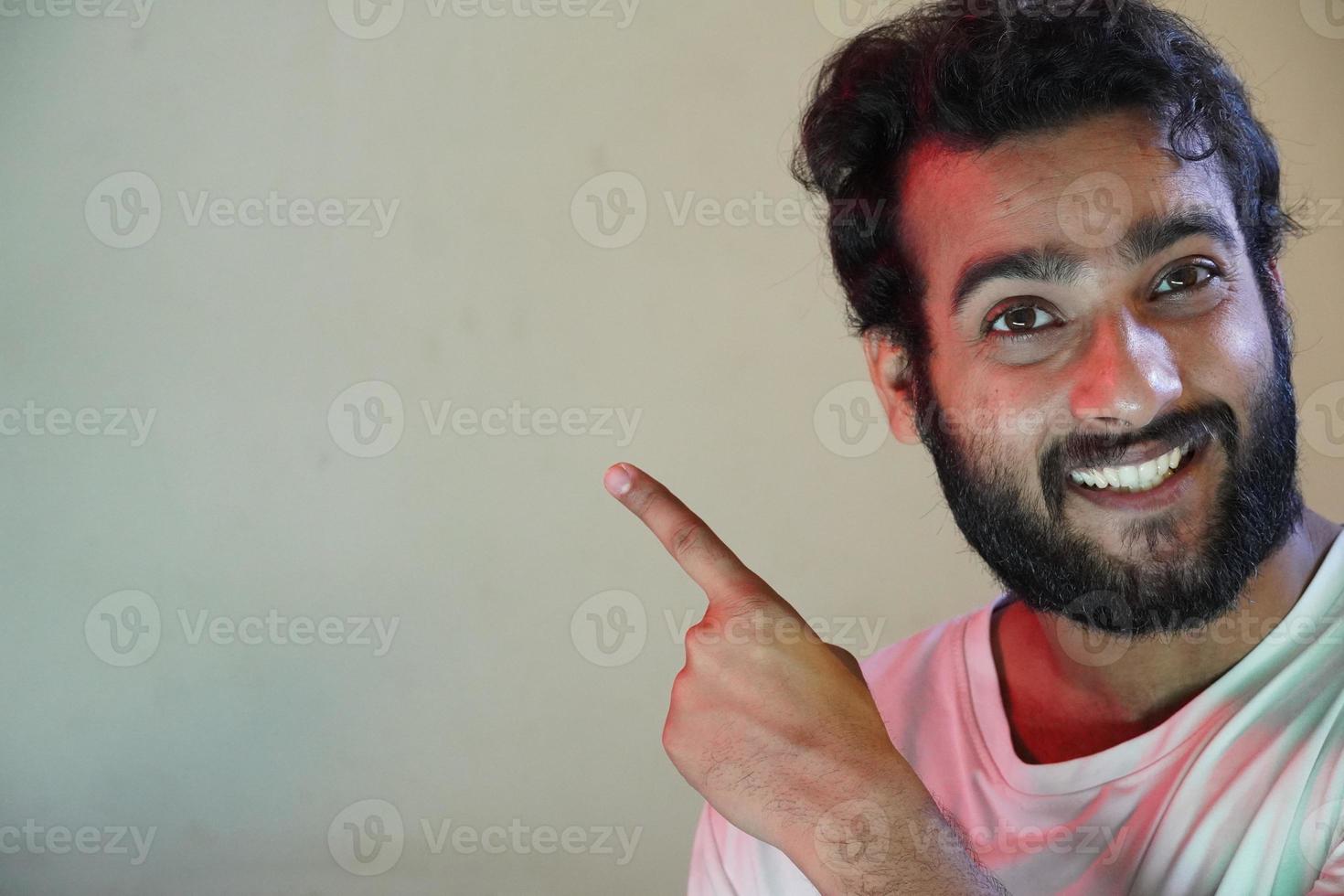 man showing something in left side using hand , A handsome young man portrait smiling photo