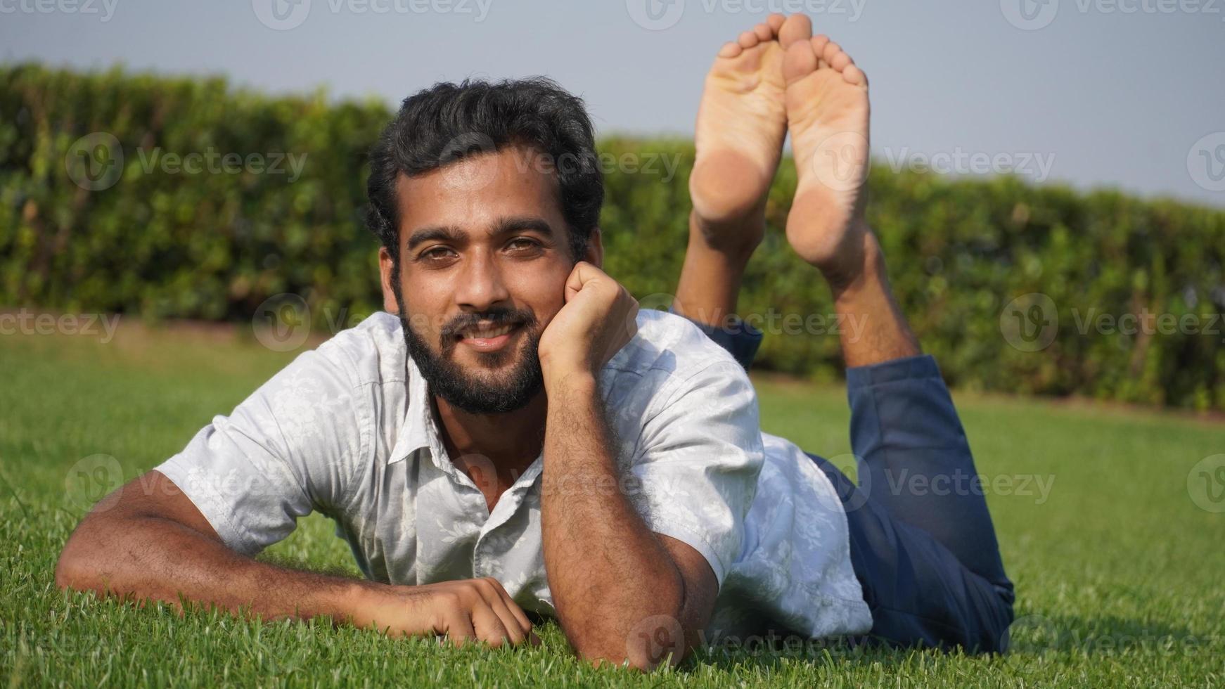 hombre en pasto y sonriendo foto