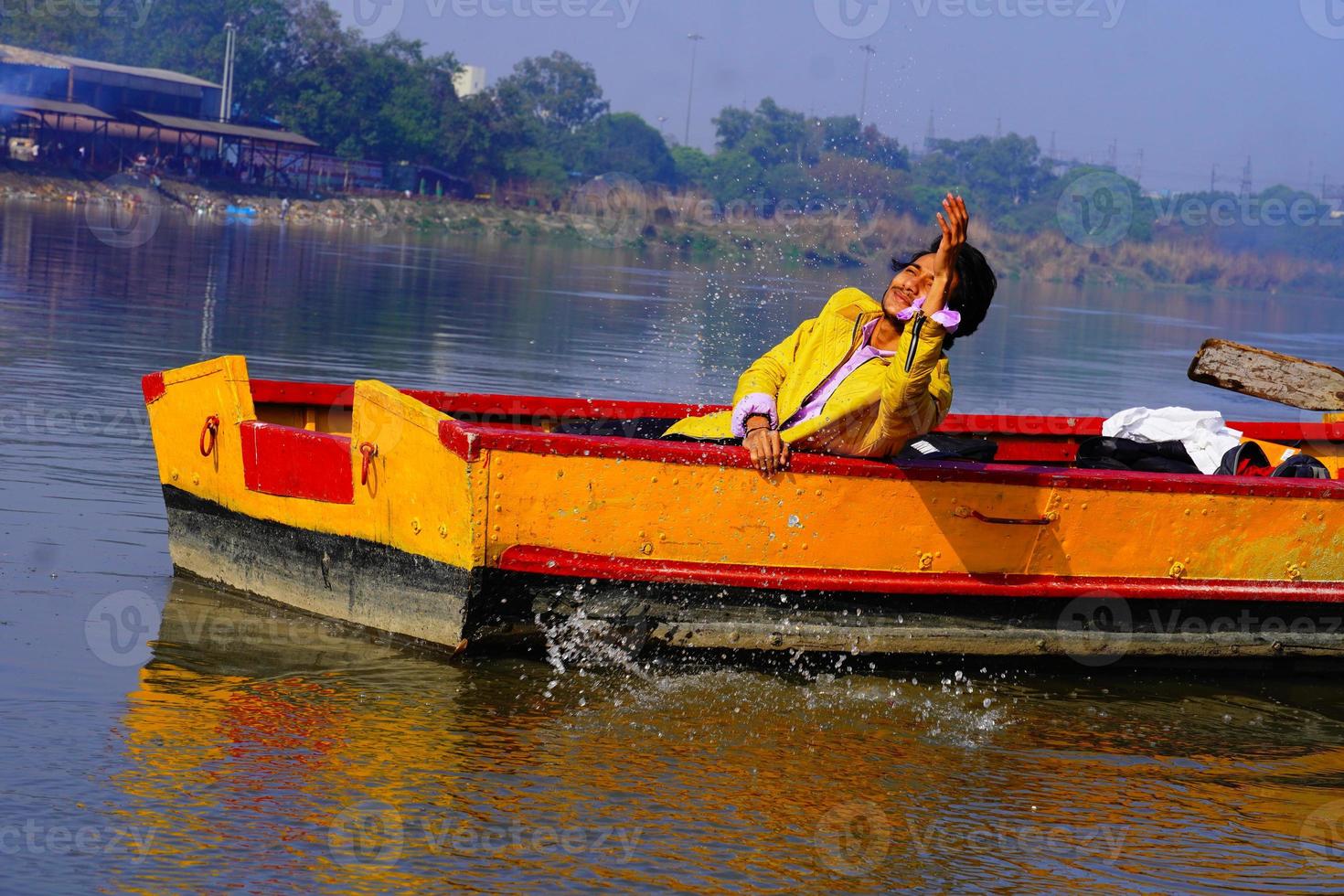 man enjoy with water sitting in the boat photo