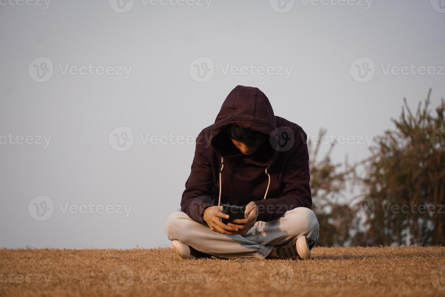Young depressed boy sit in the park photo