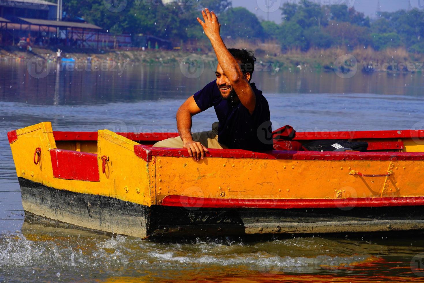 el hombre disfruta con agua sentado en el bote foto