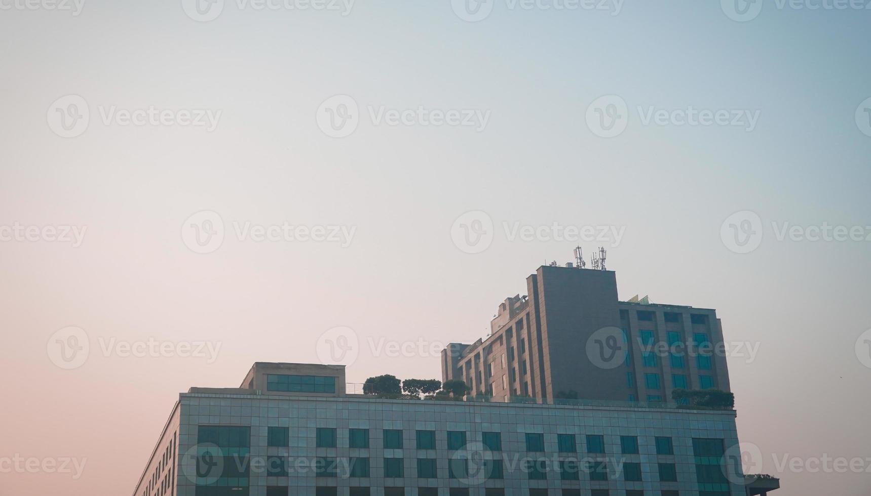 Modern glass building with reflected evening city and sunset sky in it. photo