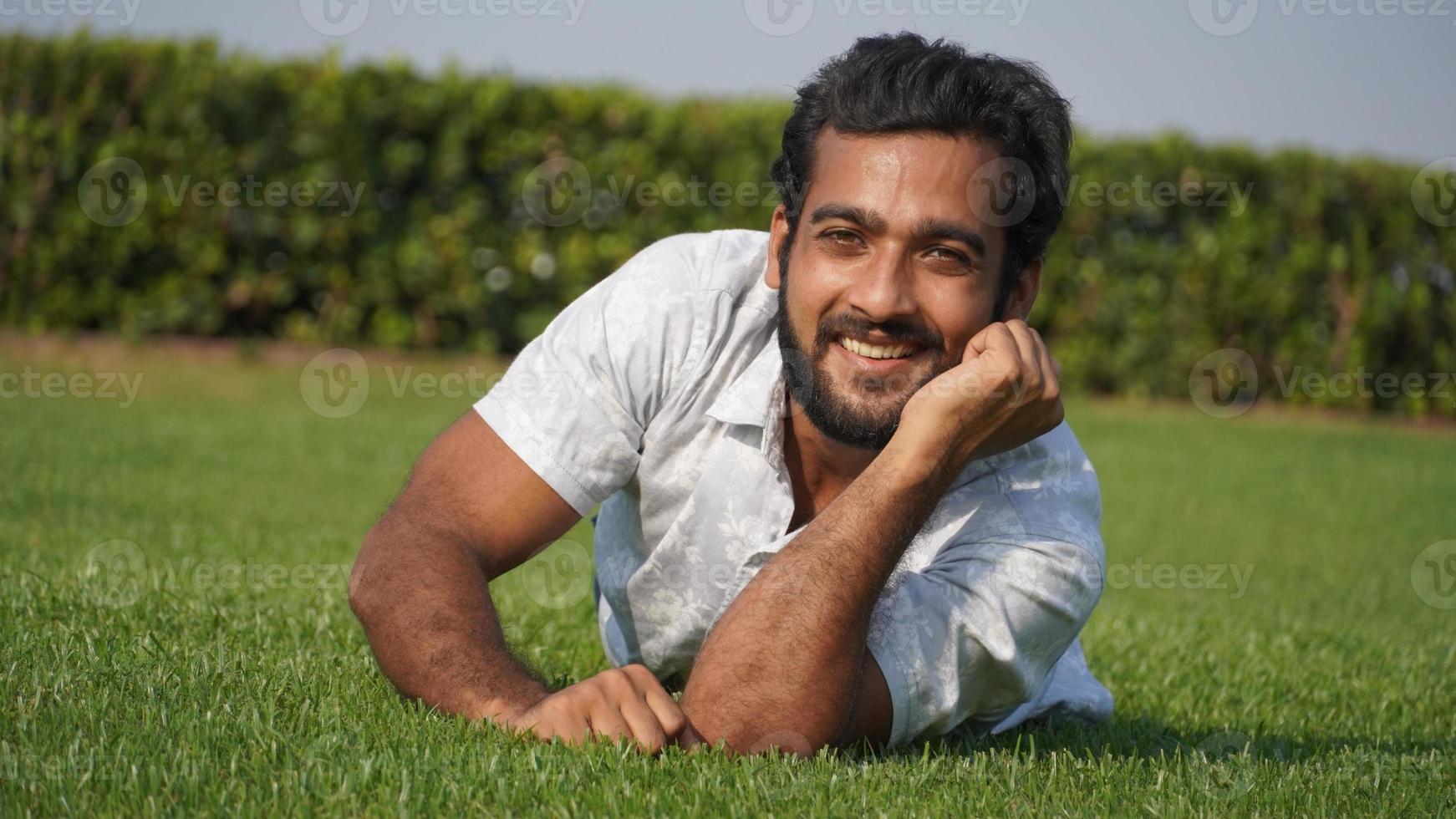 man in grass and smiling photo