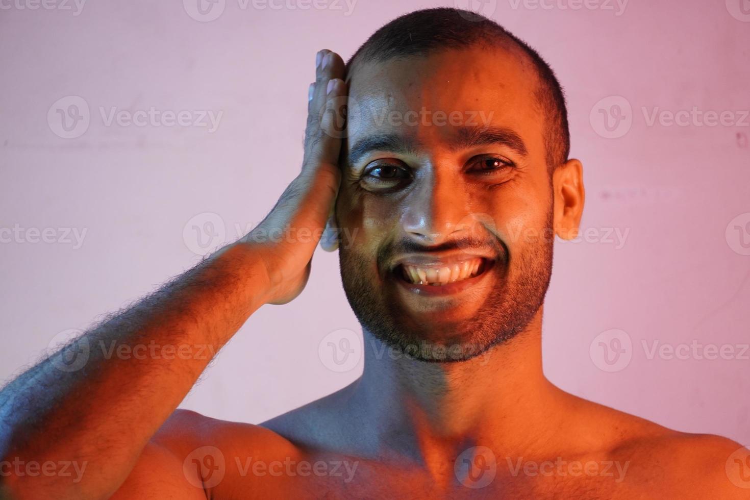 bald man smiling in pink background photo