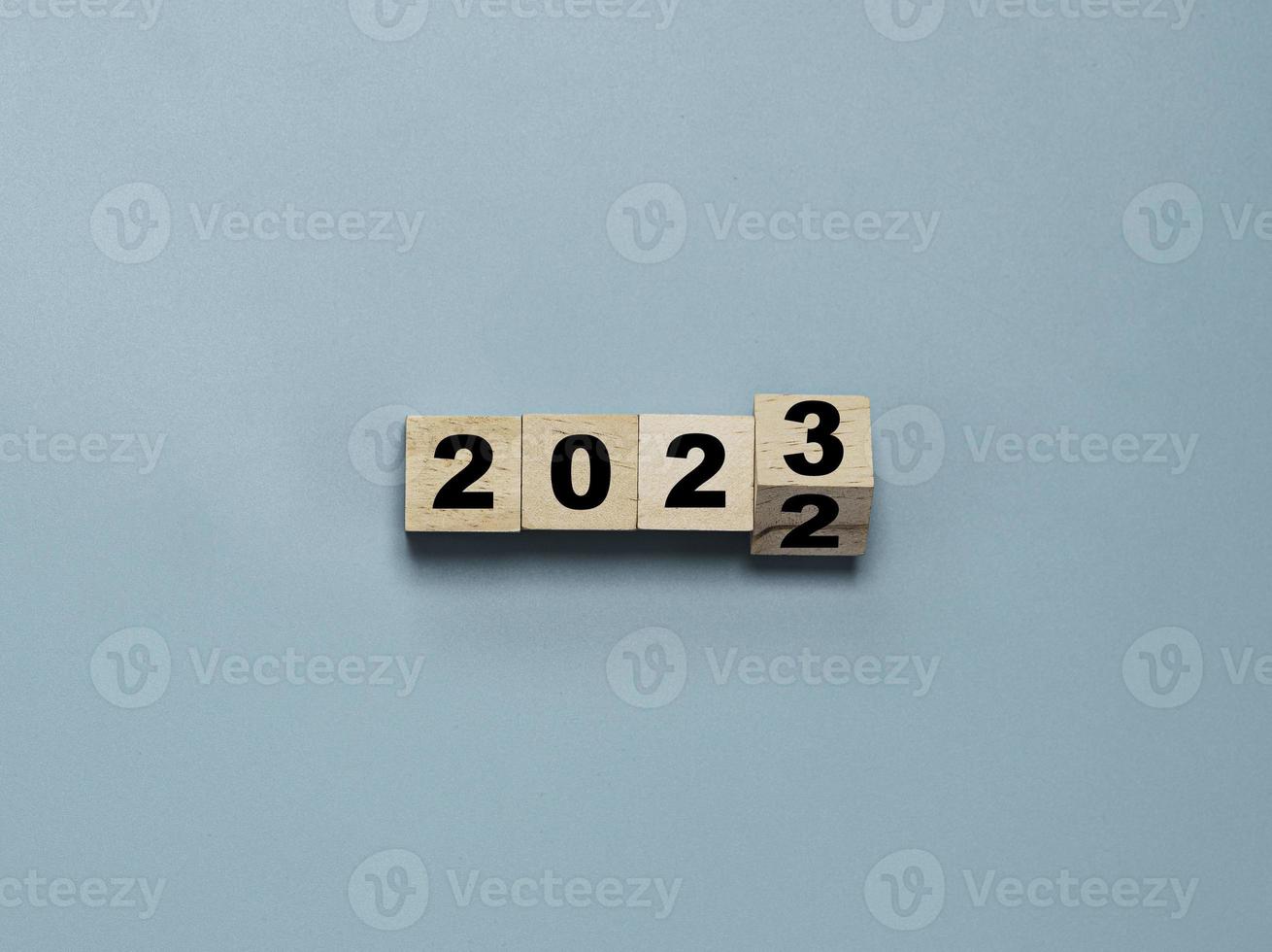 cubo de bloque de madera volteando entre 2022 y 2023 para cambio y preparación feliz navidad y feliz año nuevo. foto