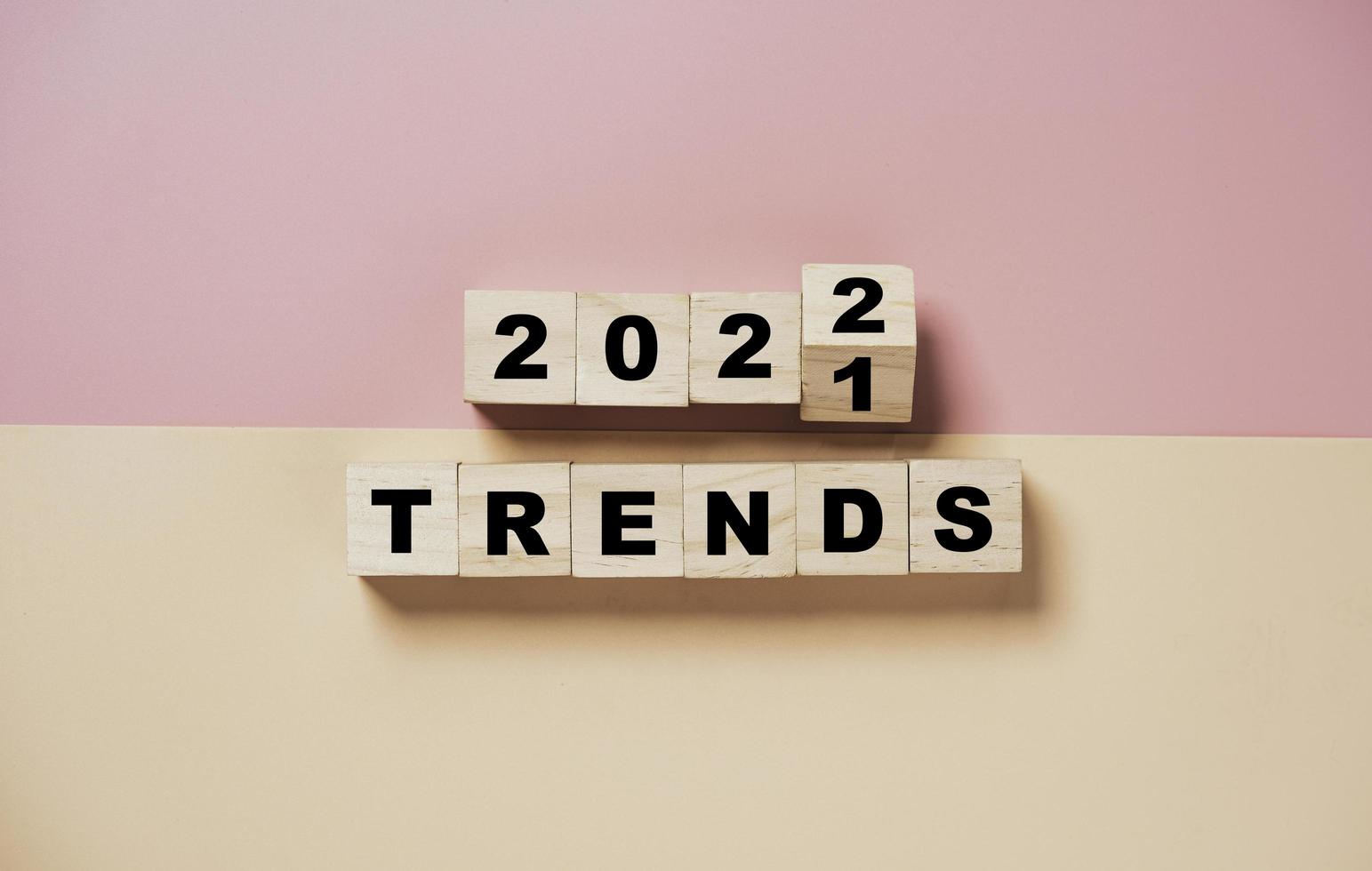 Flipping of 2021 to 2022 on wooden cube block with trend wording for new year fashion trend and business change concept. photo