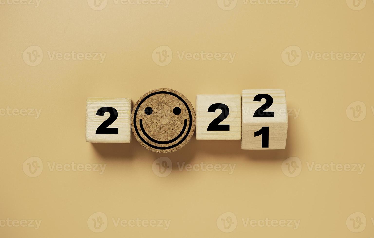 Wooden cube block flipping from 2021 to 2022 with smile face on orange background , preparation for merry Christmas and happy new year and 3d rendering concept. photo