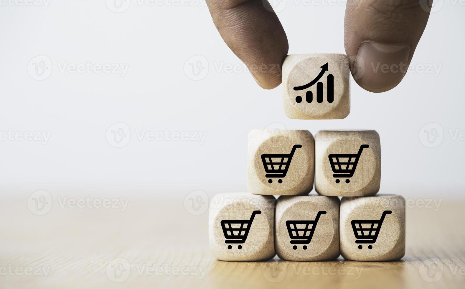 Hand holding wooden cube block stacking which print screen shopping trolley cart and investment graph for sale amount increasing and business growth concept. photo