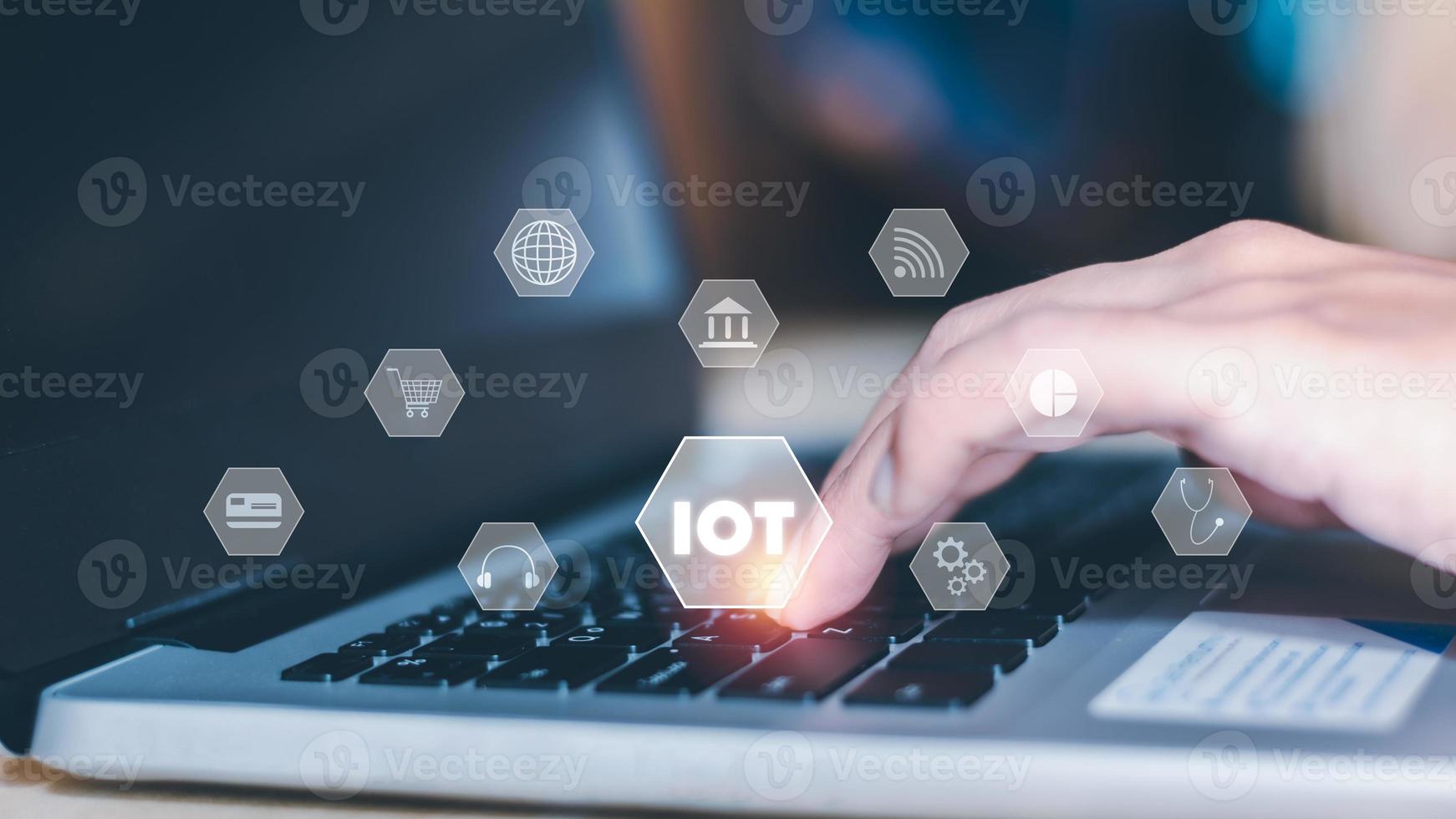 IoT internet of thing concept. Businessmen use a laptop with an interface popup of icons such as earth, wifi, internet banking, credit card, data, telemedicine, and online shopping. photo