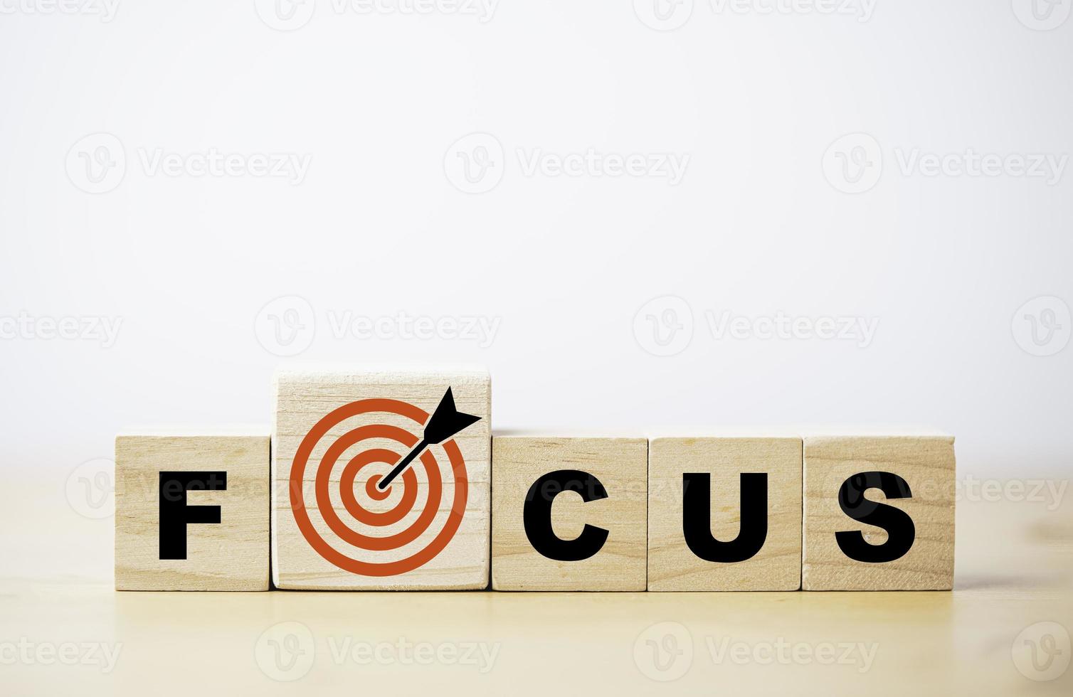 Focus wording on wooden cube block with red dartboard and arrow drawing for concentrate with business objective target concept. photo