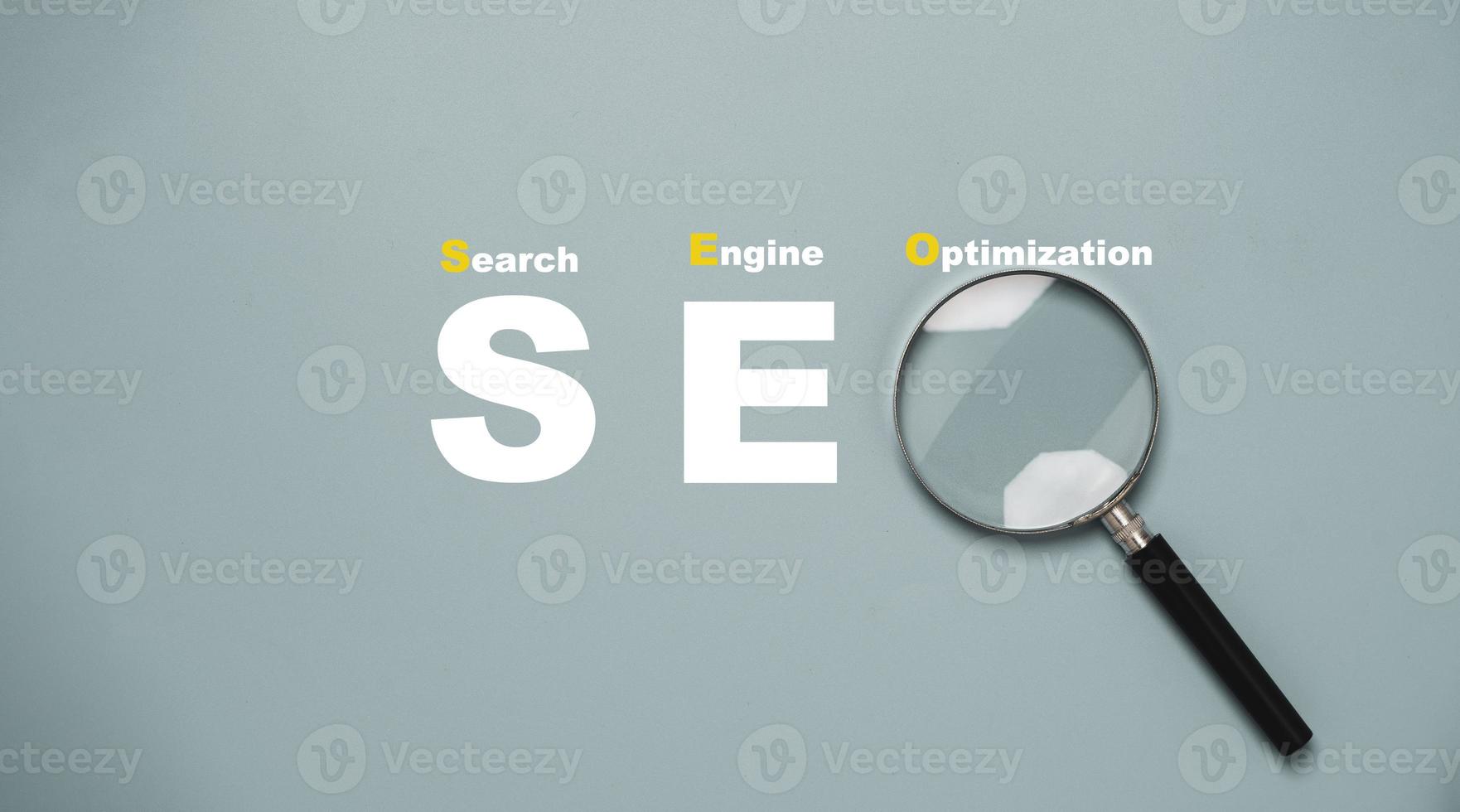 Magnifier glass with SEO or Search Engine Optimisation wording for search engine concept. photo