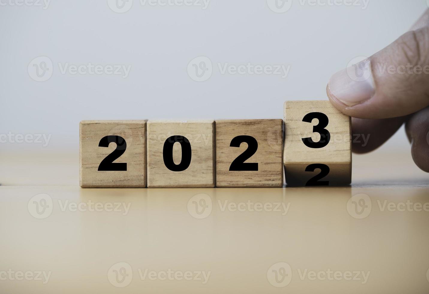 cubo de bloque de madera volteando entre 2022 y 2023 para cambio y preparación feliz navidad y feliz año nuevo. foto