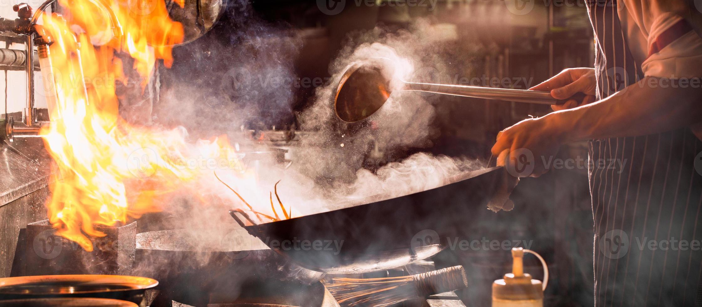 Chef stir fry busy cooking in kitchen. photo