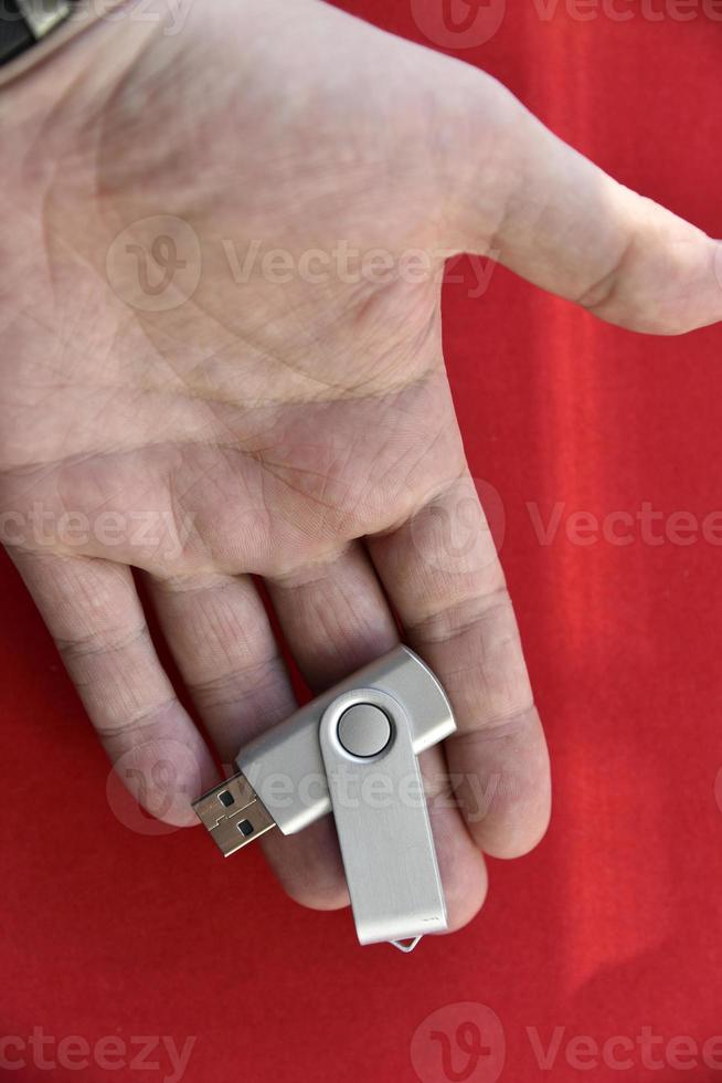 USB flash drive in the palm of your hand on a red background photo