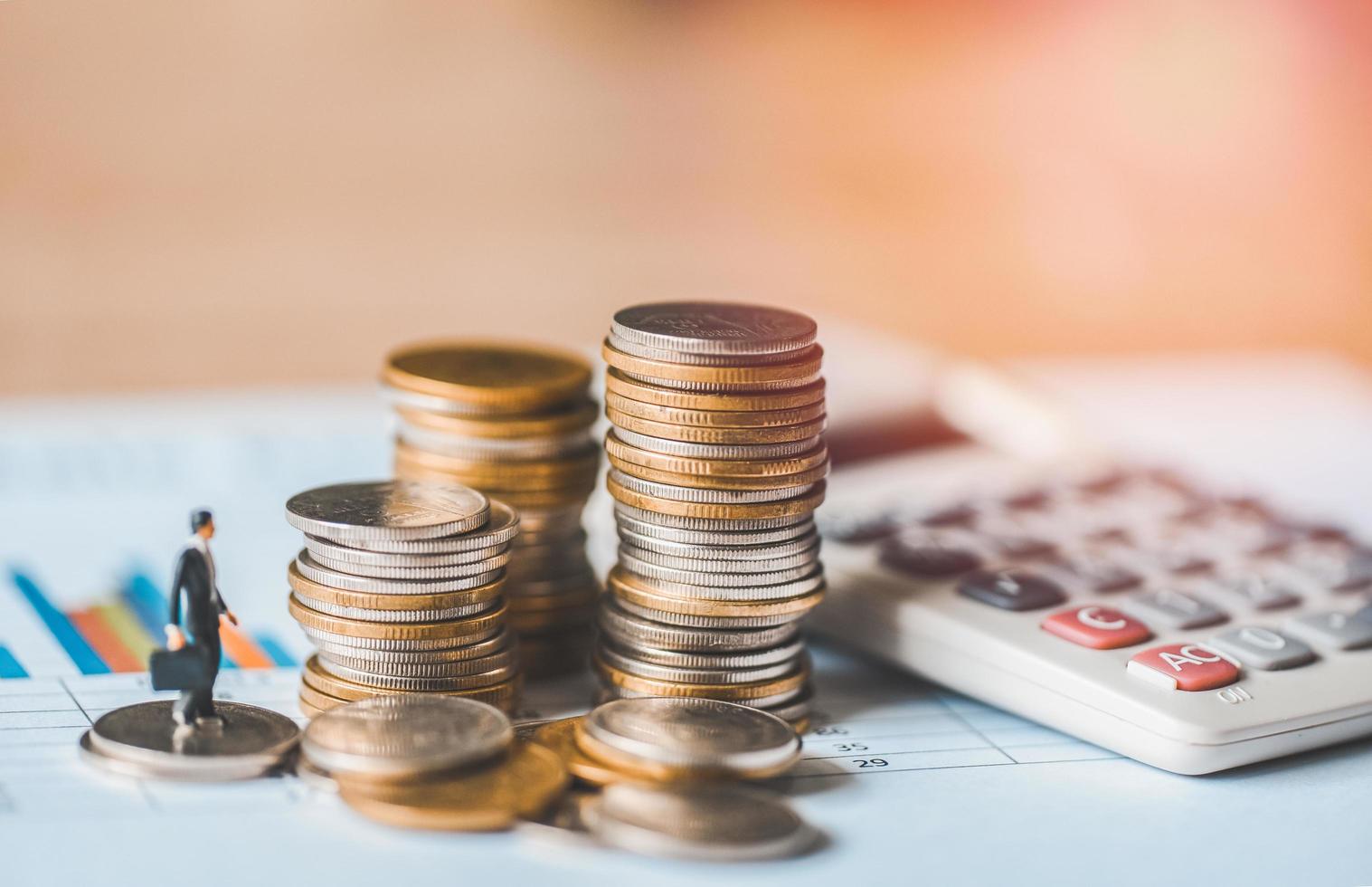 stacked coins financial and business man on business graph paper with calculator analysis of business investment concept money photo