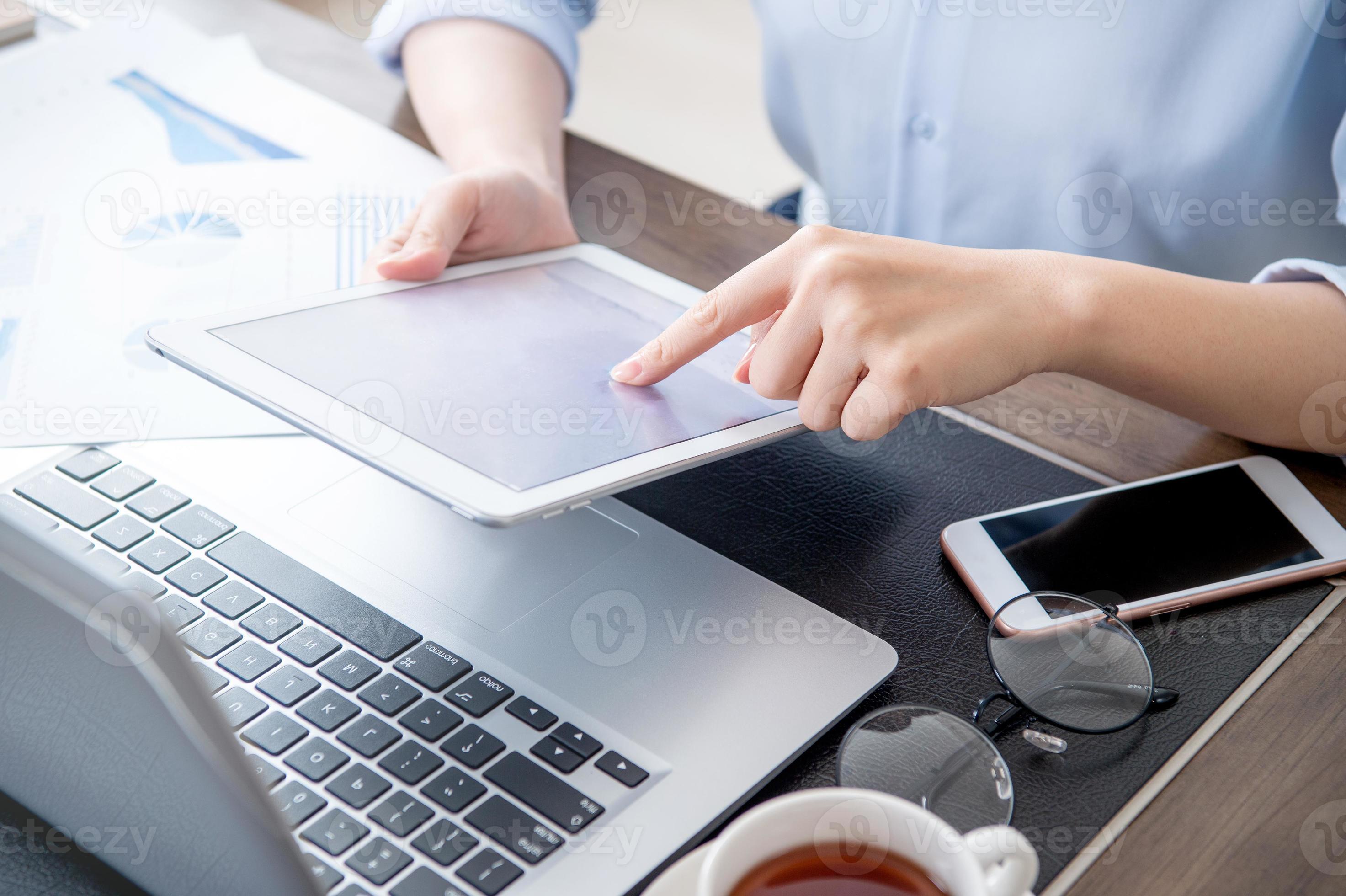 Business concept. Woman using tablet for project with digital device in office desk