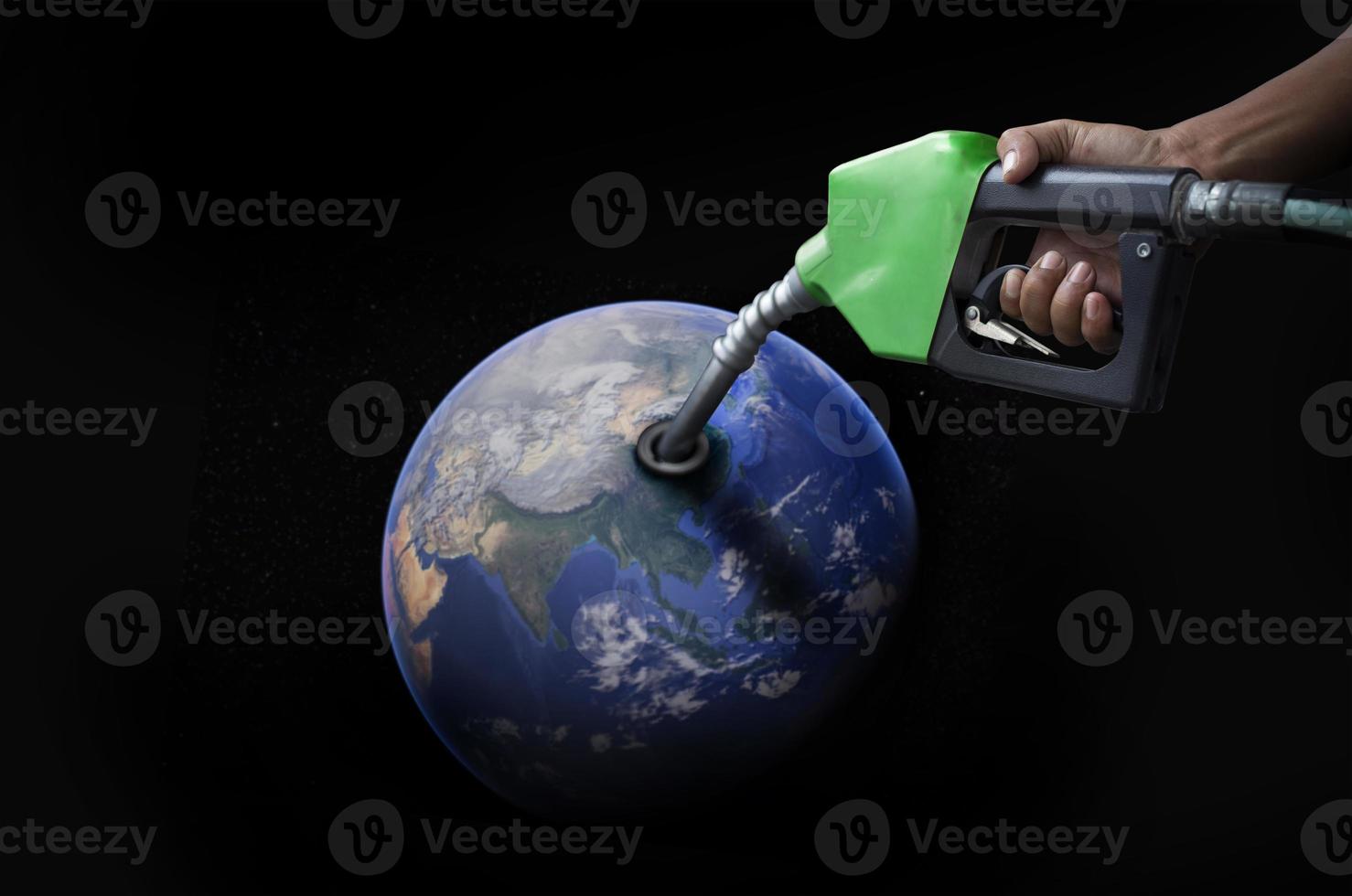 world oil economic Concept image of the world oil condition from the hand refueling oil pump nozzle photo