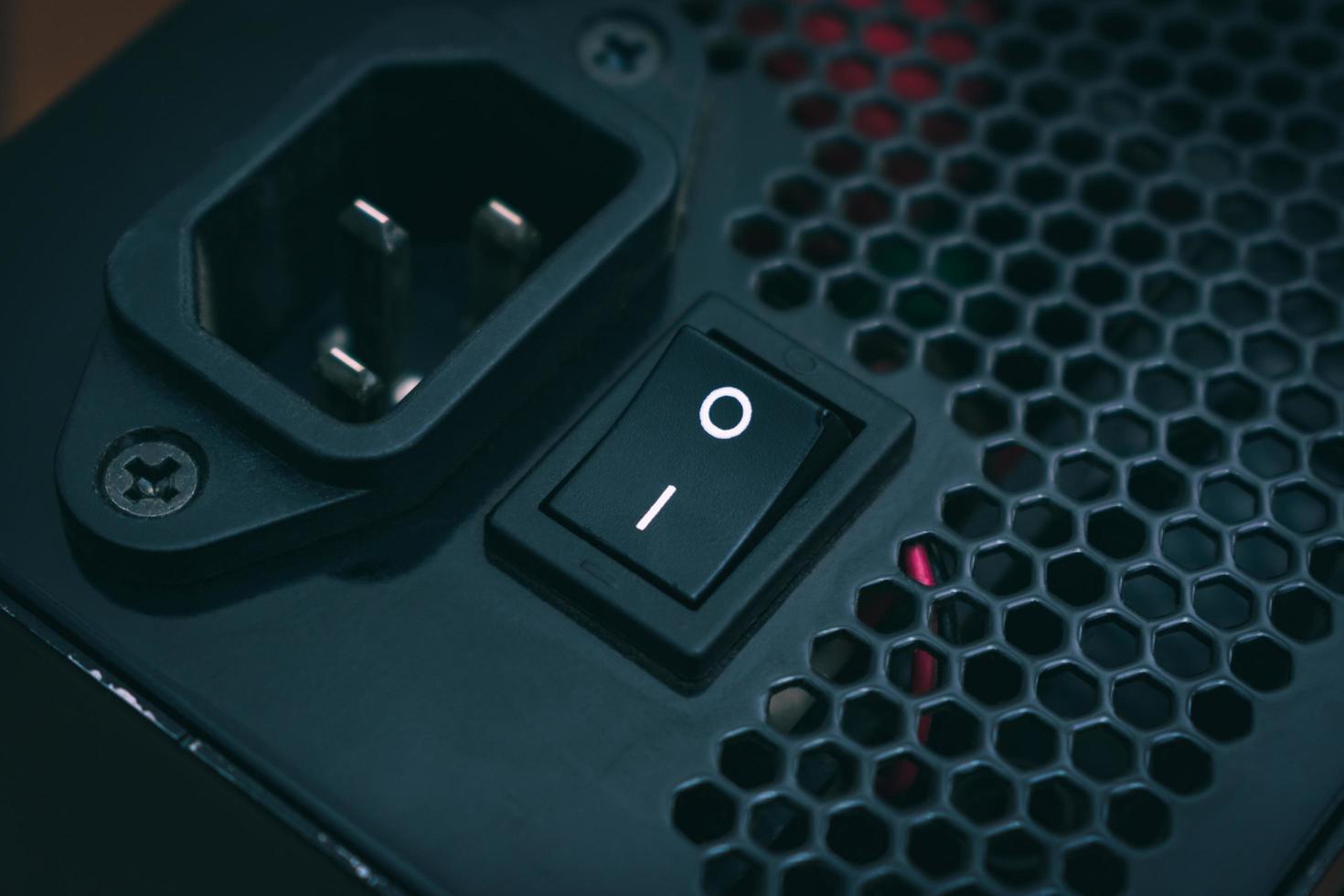 Button and socket of the power supply of a personal computer close-up in dark colors photo