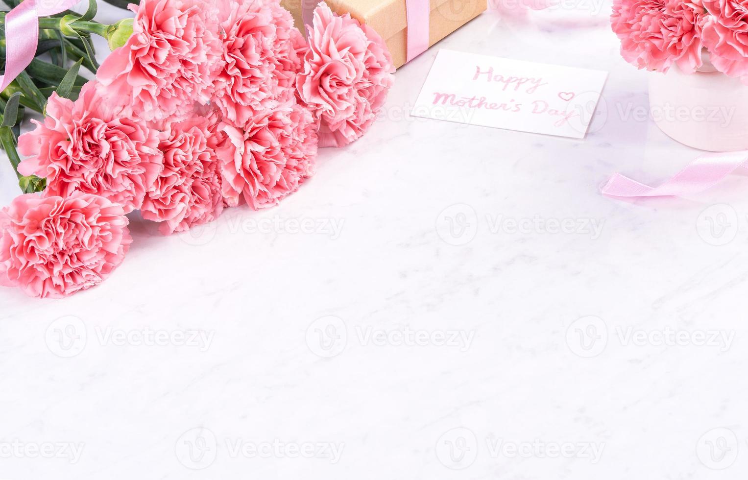 Design concept - Beautiful bunch of carnations on marble white background, top view, copy space, close up, mock up. Mothers day gift idea inspiration. photo