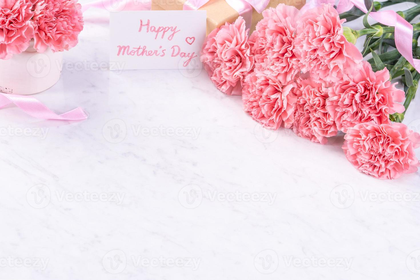 Design concept - Beautiful bunch of carnations on marble white background, top view, copy space, close up, mock up. Mothers day gift idea inspiration. photo