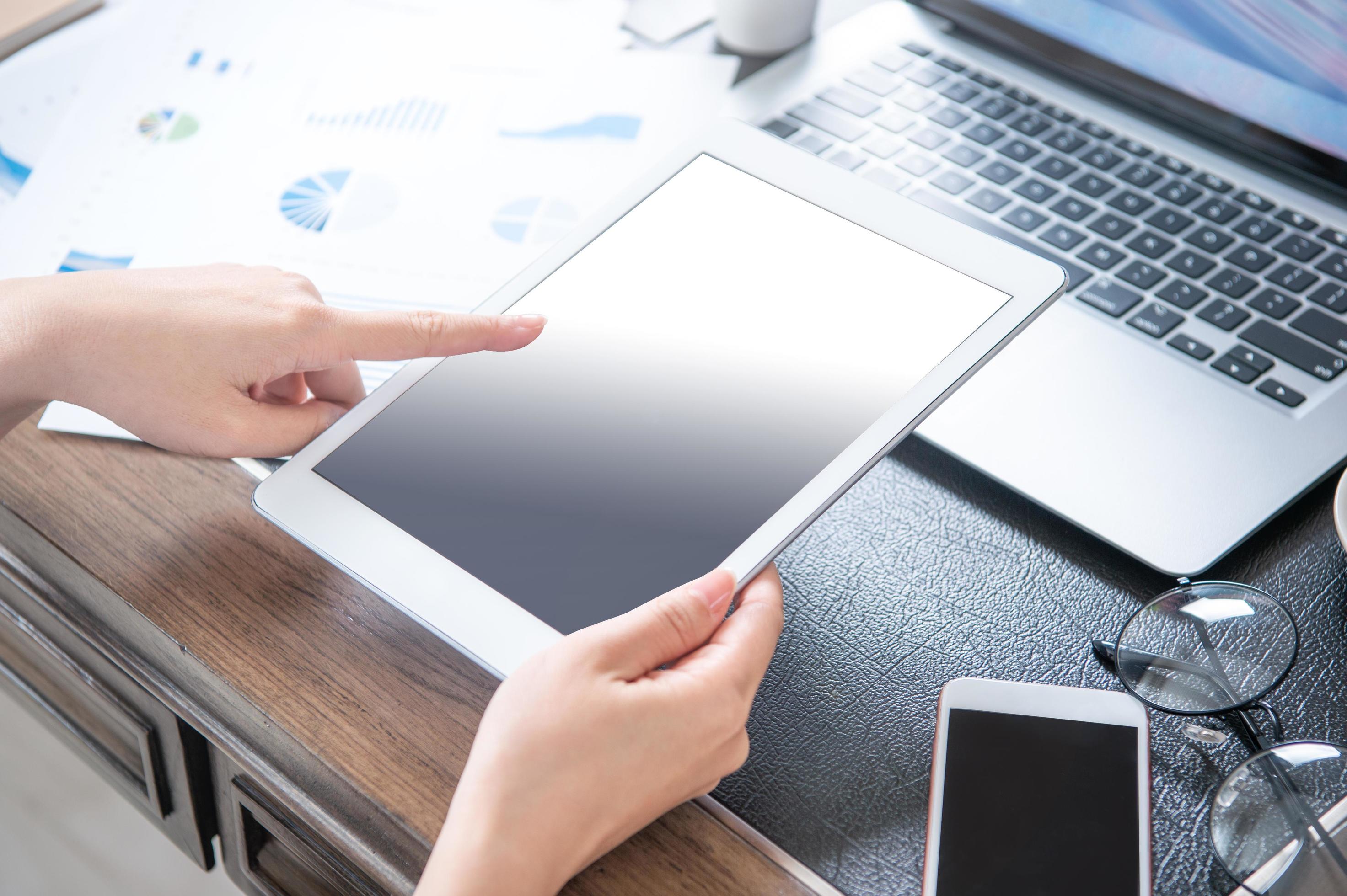 Business concept. Woman using tablet for project with digital device in office desk
