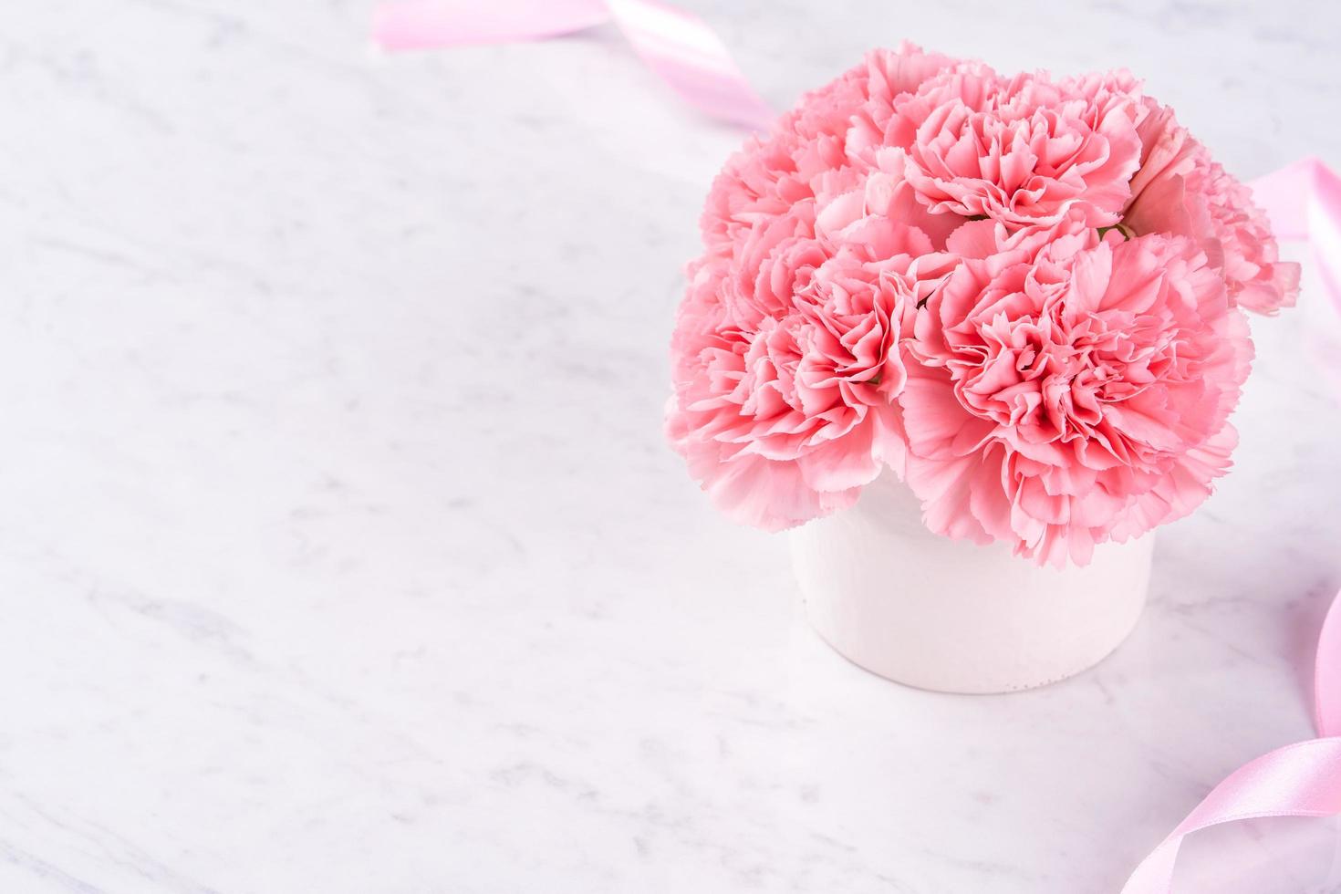 Copy space, close up, mock up, clipping path. Mothers day wording concept design. Beautiful fresh blooming baby pink color carnations isolated on bright marble background. photo