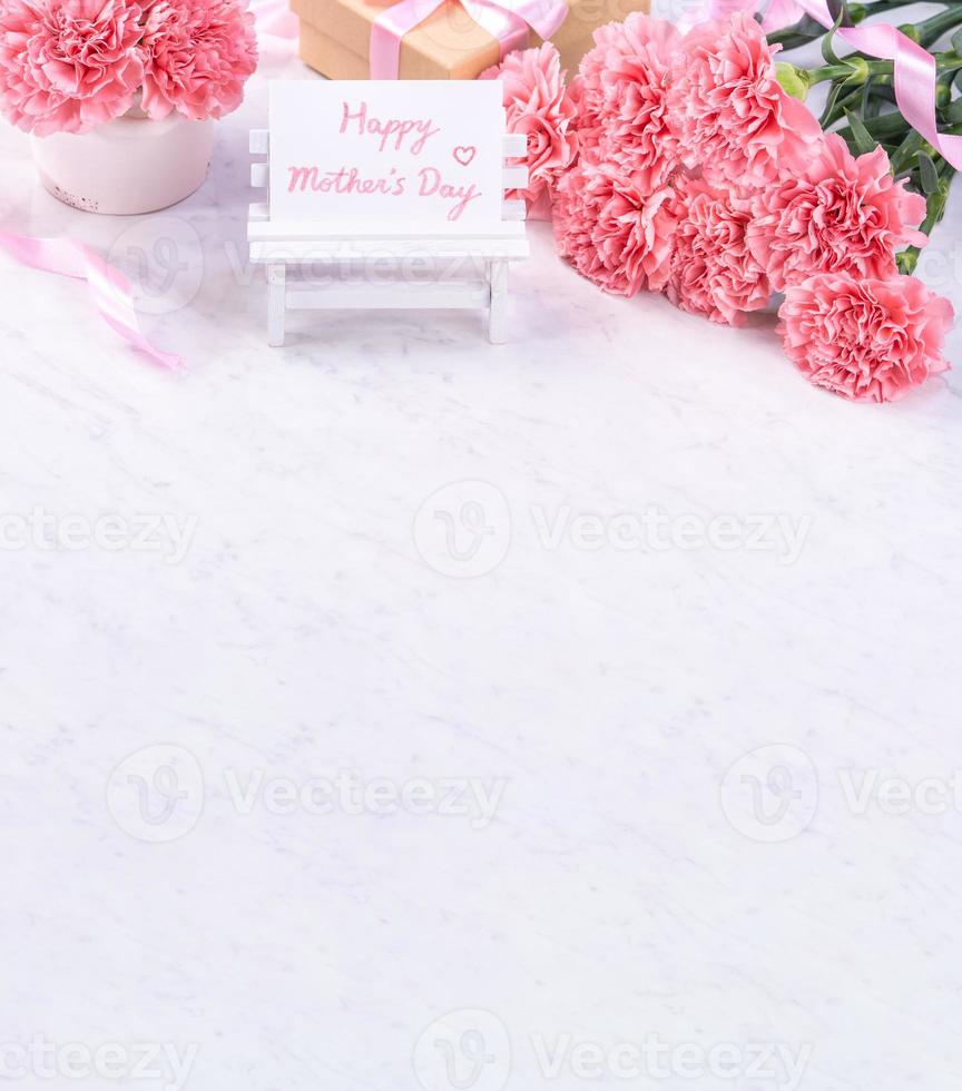 Design concept - Beautiful bunch of carnations on marble white background, top view, copy space, close up, mock up. Mothers day gift idea inspiration. photo