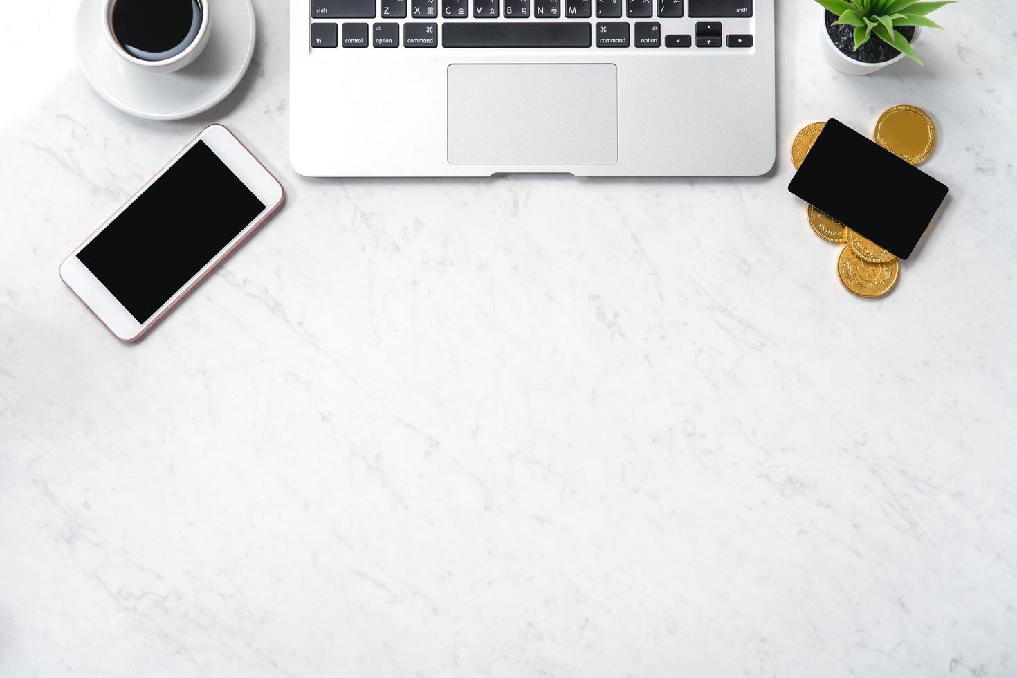 Business financial design concept, marble white office table desk top view with smart phone, mockup credit card, coins, laptop, flat lay, copy space photo