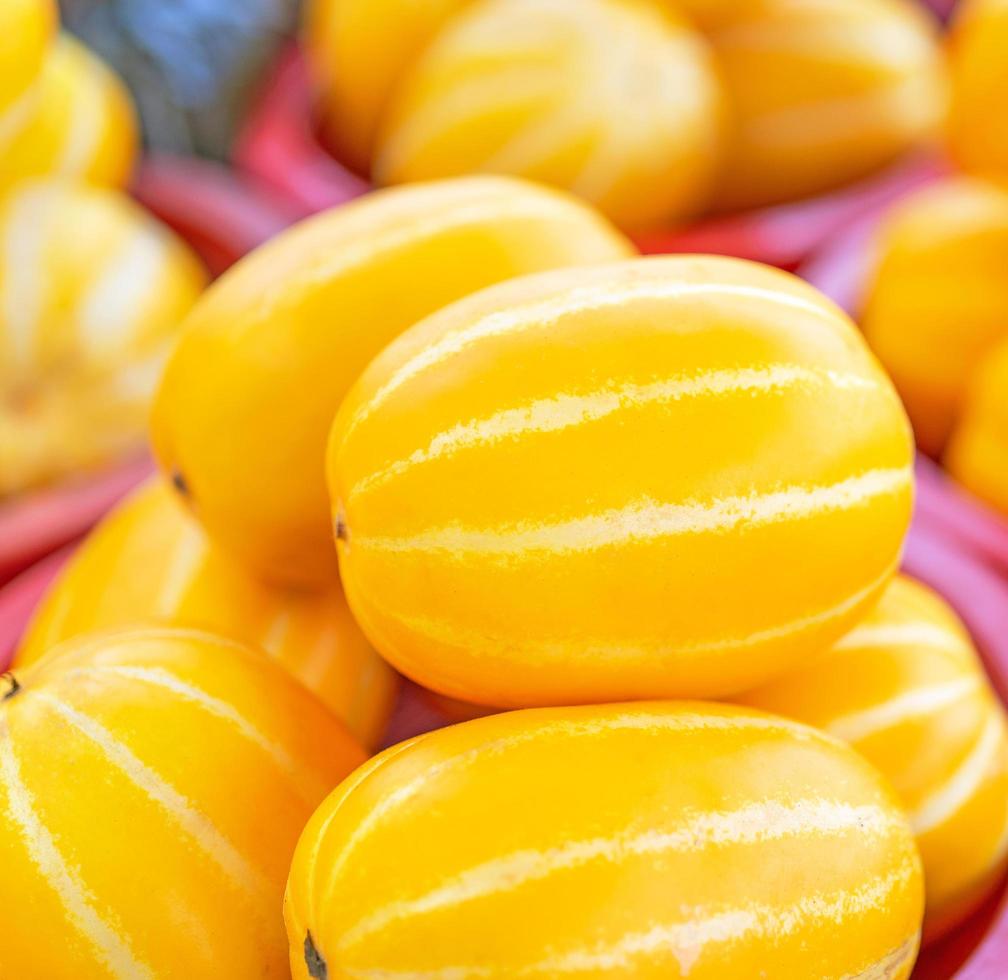 Delicious korean stripe yellow melon fruit food in red plastic basket at tradition market afternoon, Seoul, South Korea, harvest concept, close up. photo